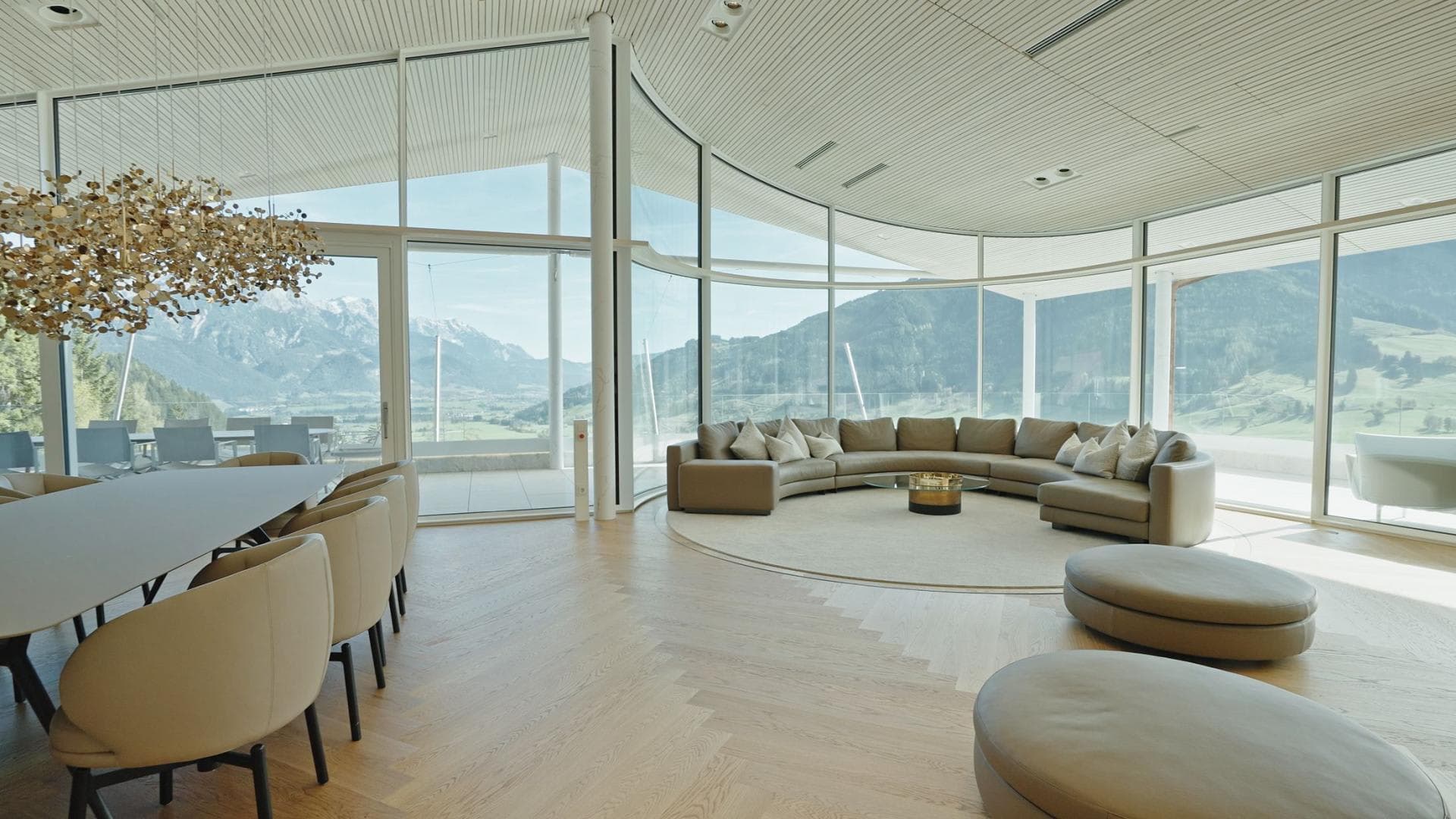 Open-plan living area with curved sectional and panoramic mountain views