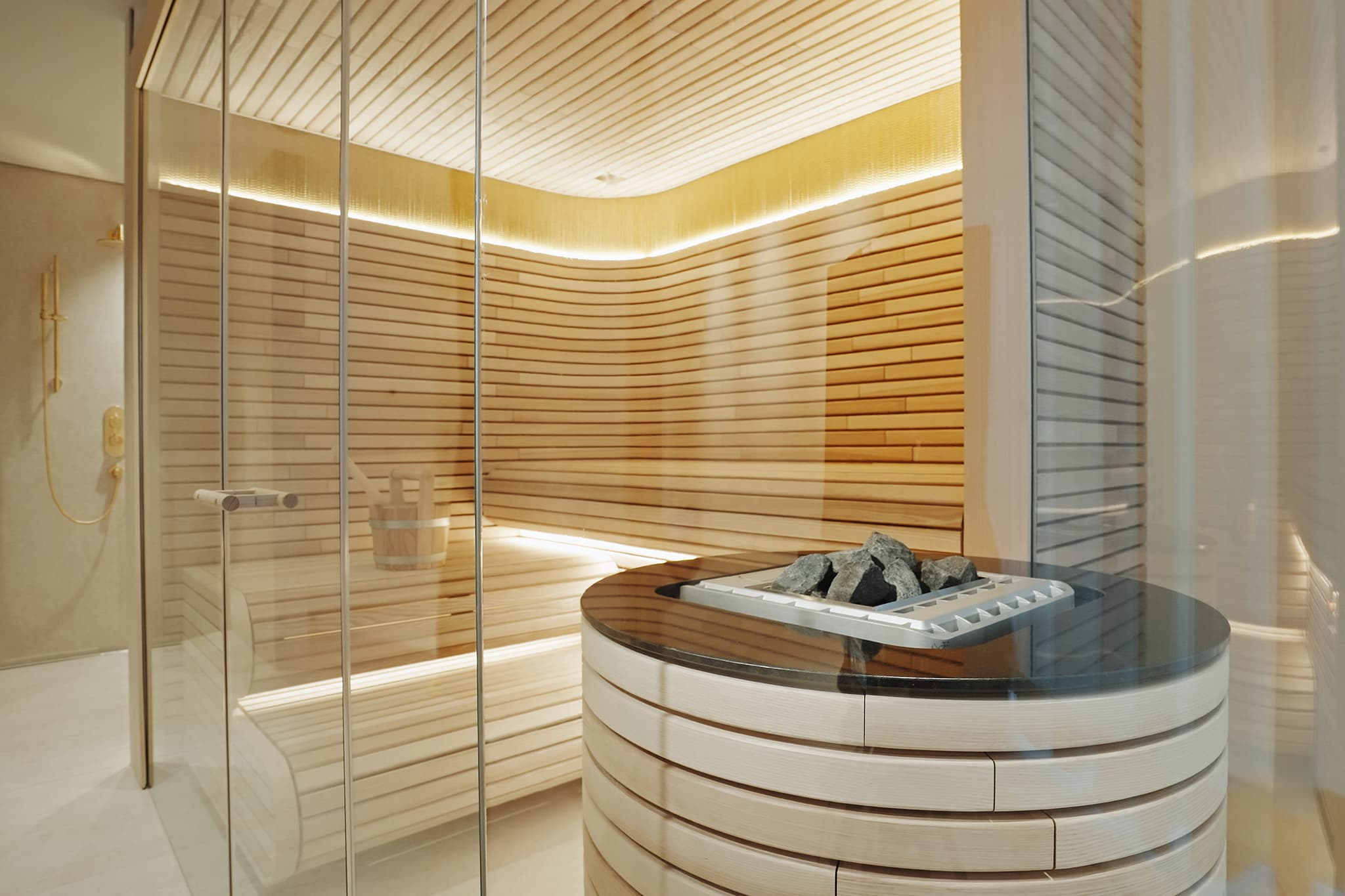 Private sauna with tiered seating and adjacent walk-in shower