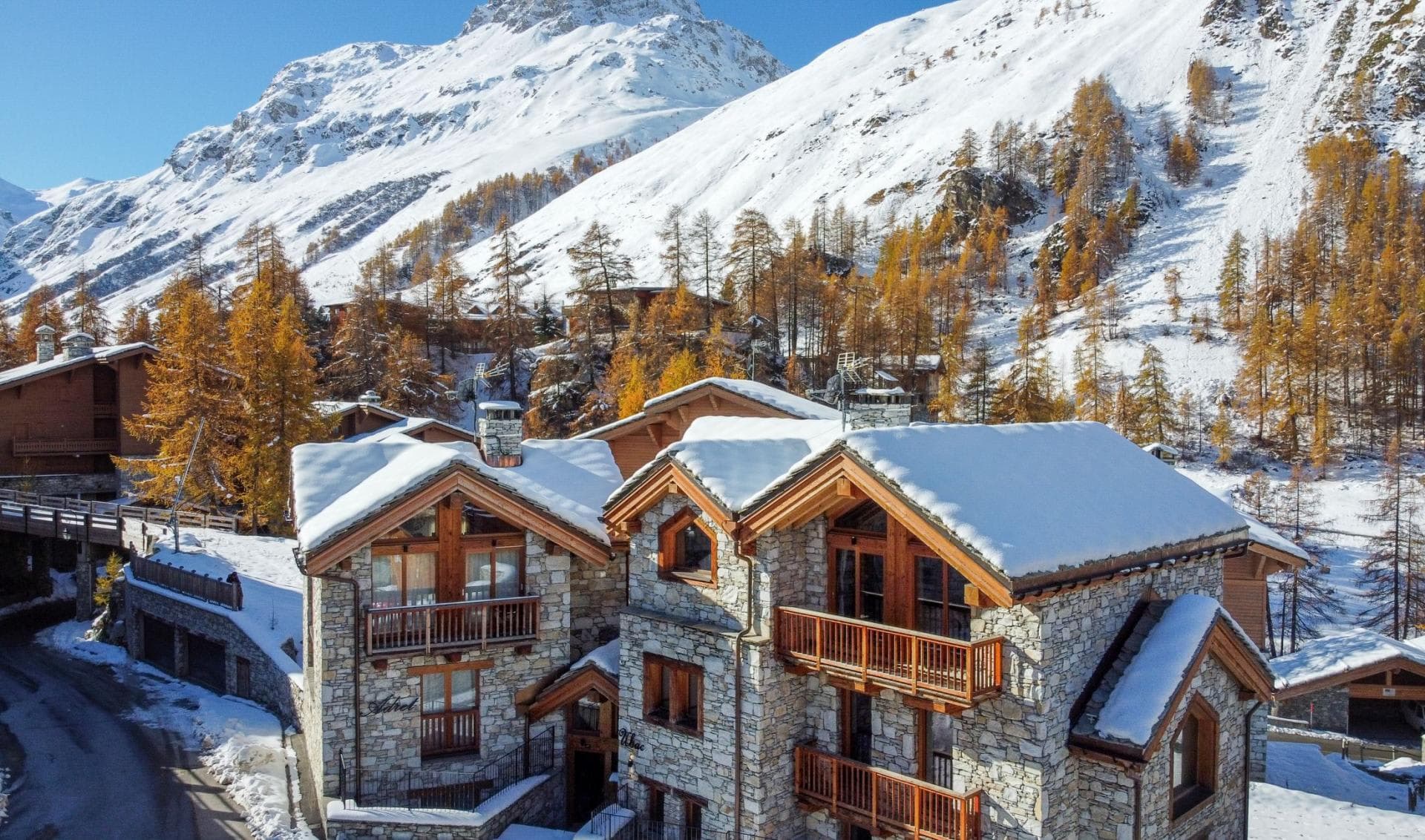 Stone-clad alpine chalet exterior featuring multiple private balconies and mountain views