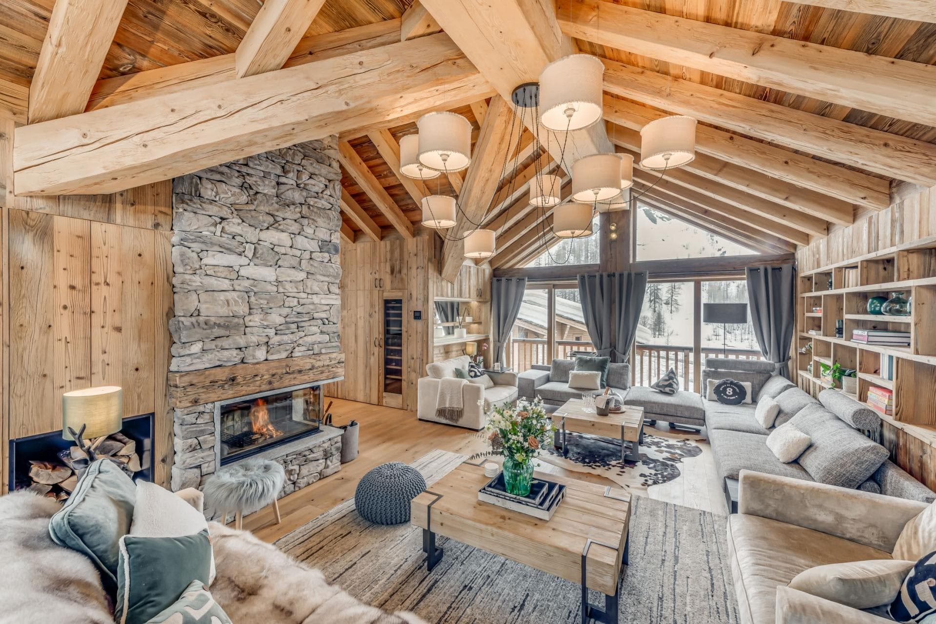 Living area with wood-burning fireplace and floor-to-ceiling windows overlooking slopes