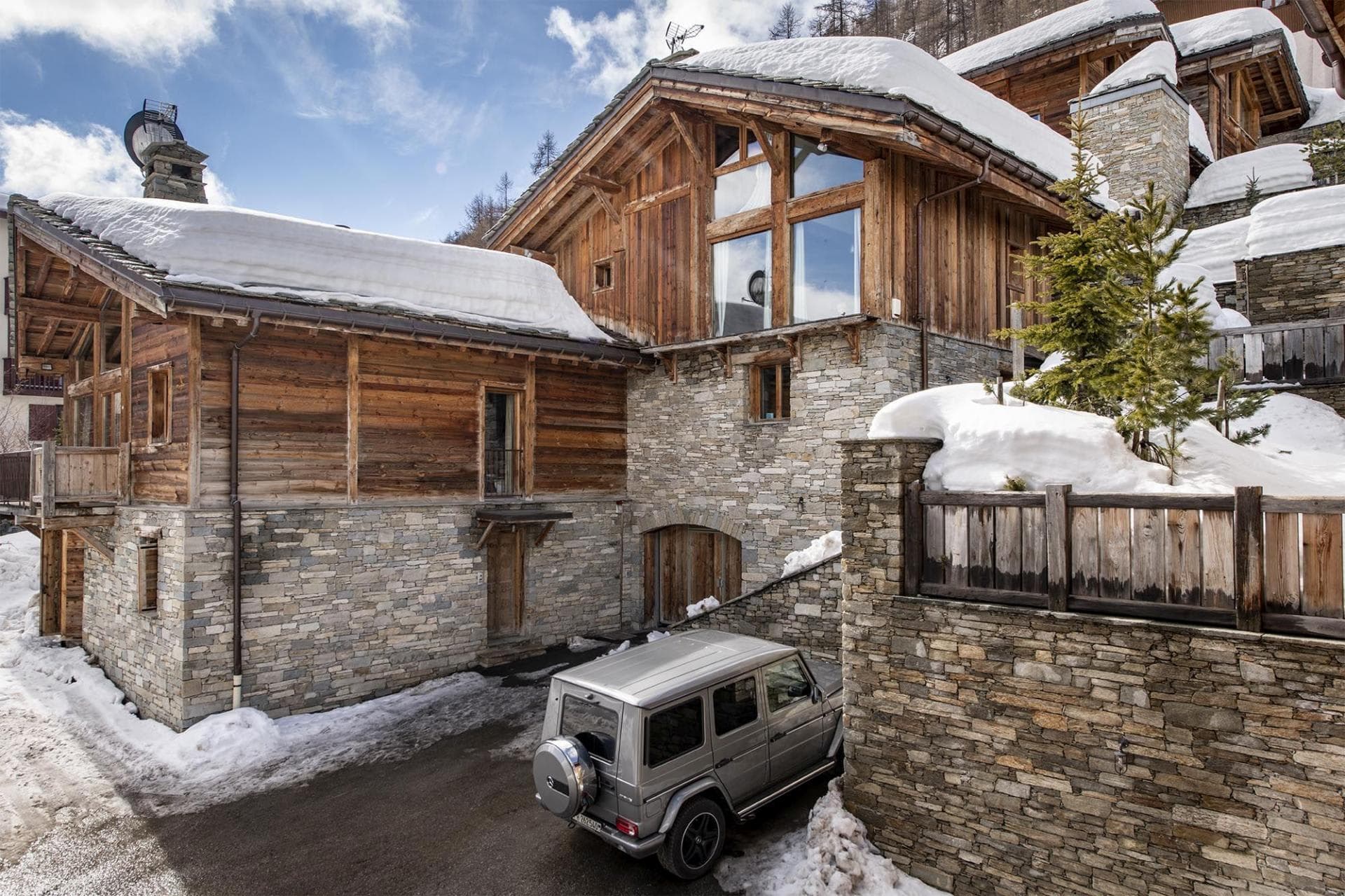 Stone and timber chalet exterior with private driveway parking