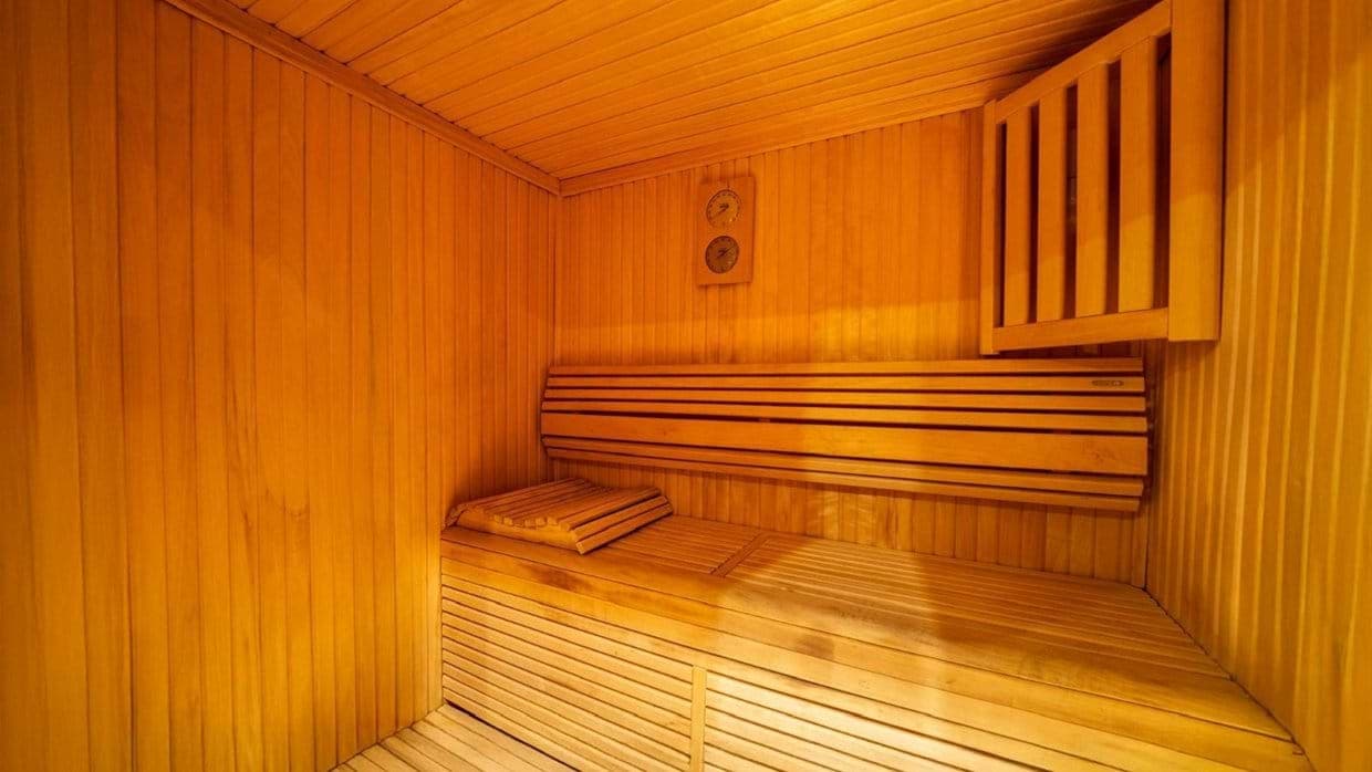 Private wood sauna with bench seating and integrated headrest