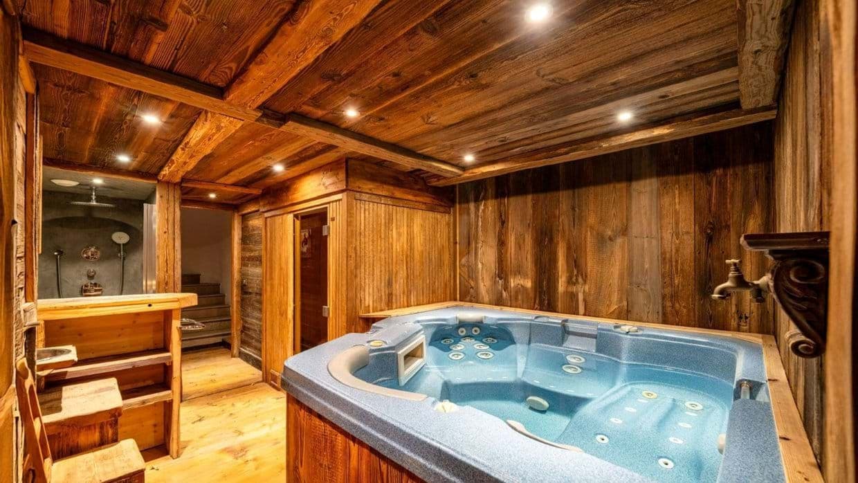 Indoor hot tub and walk-in rain shower with rustic wood paneling