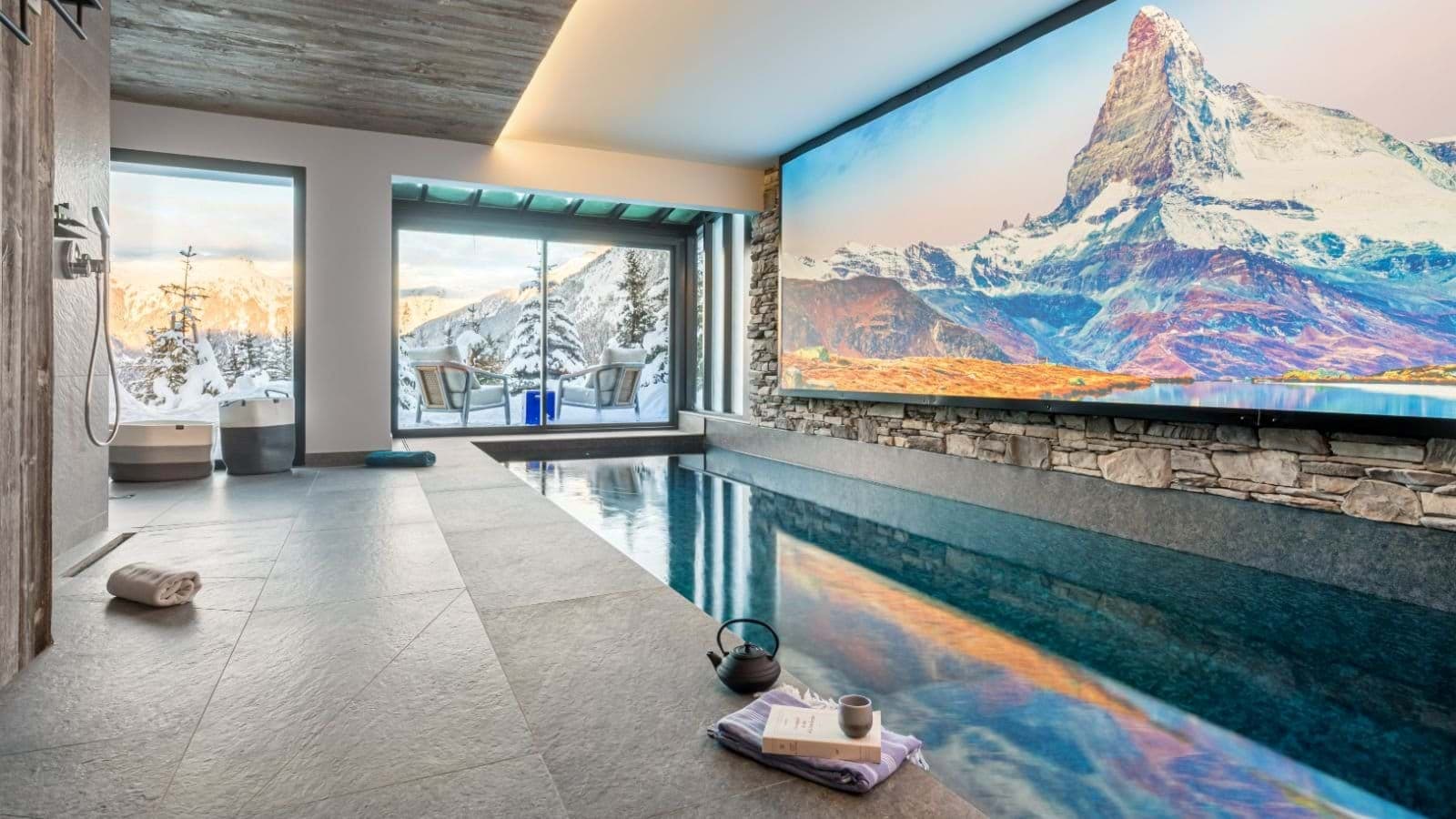 Indoor lap pool featuring large digital screen and mountain views