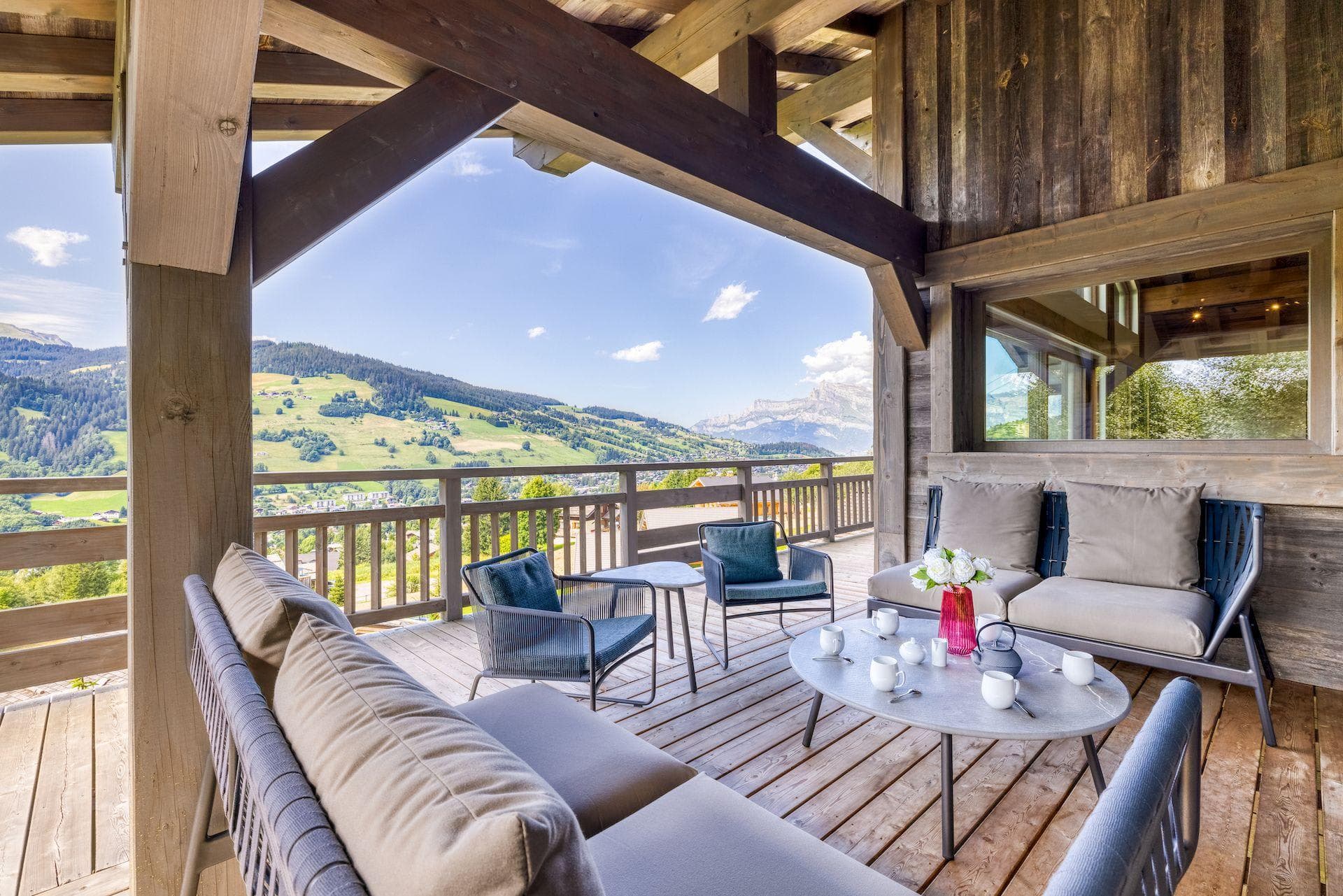 Covered timber balcony with lounge seating and panoramic alpine views