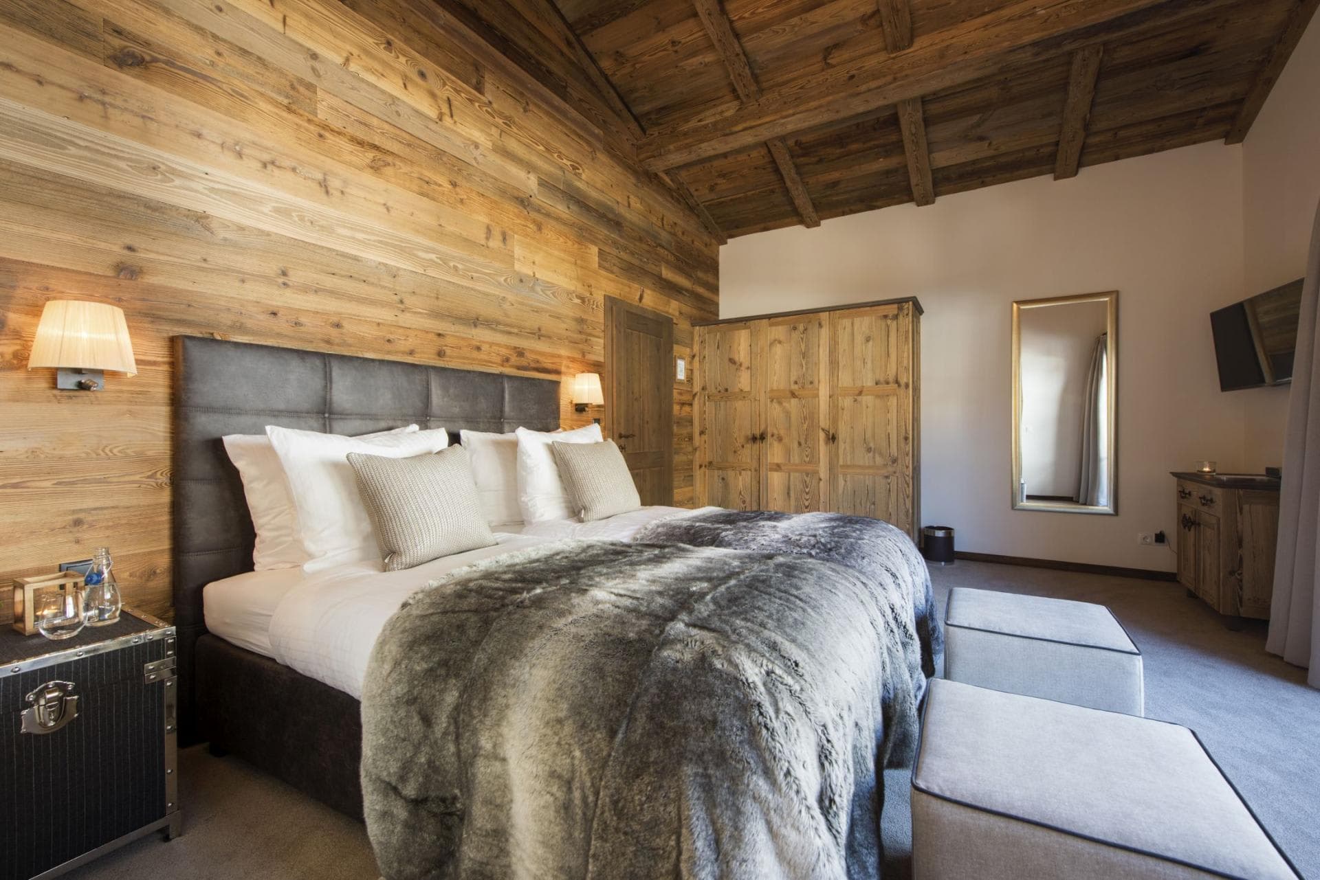 Bedroom with split-king bed, reclaimed wood walls, and large wardrobe