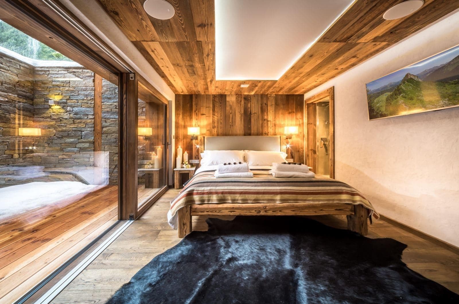 Primary bedroom with reclaimed wood paneling and private terrace access