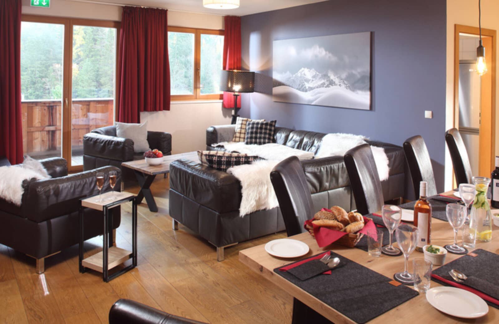 Living and dining area with leather seating and forest-view balcony