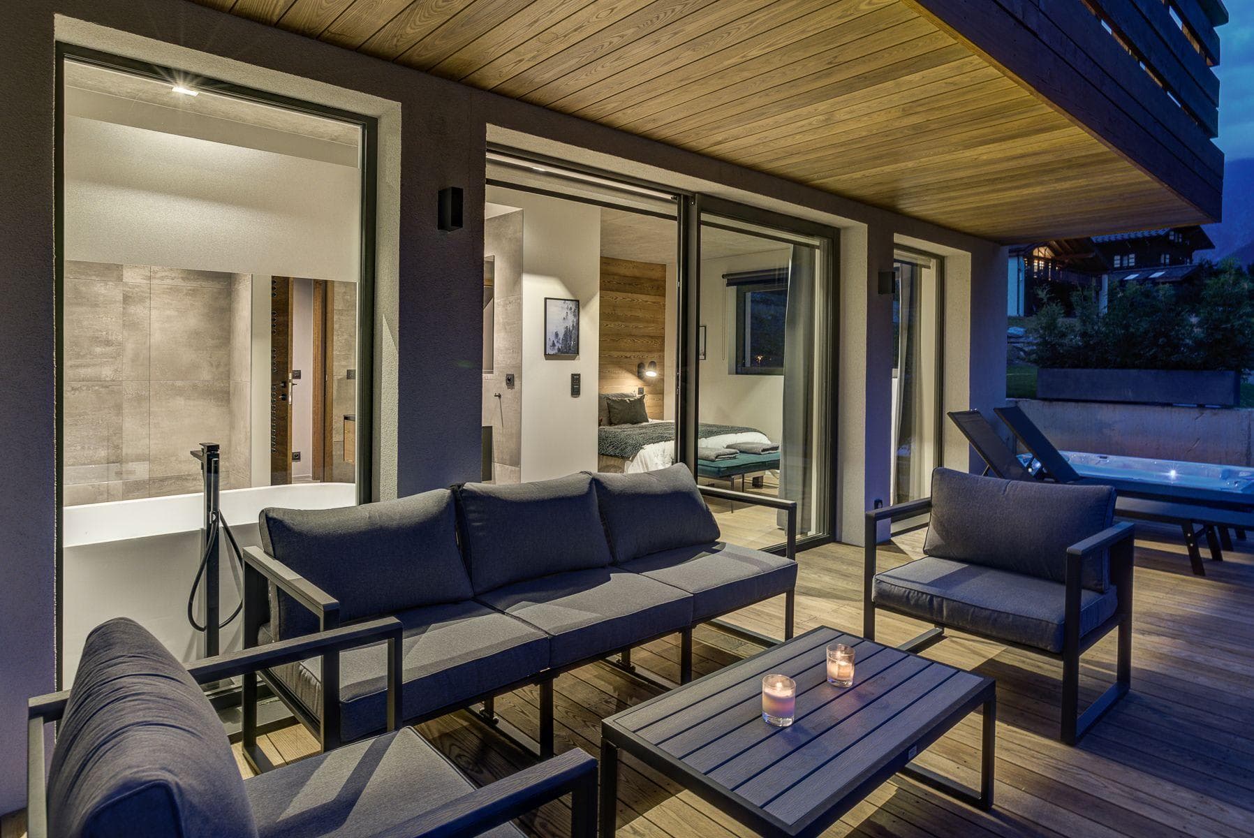 Covered terrace with lounge seating, hot tub, and direct bedroom access