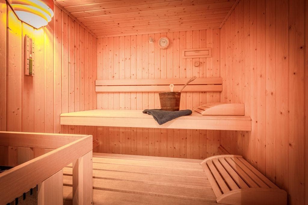 Private cedar sauna with two-tier seating and traditional ladle