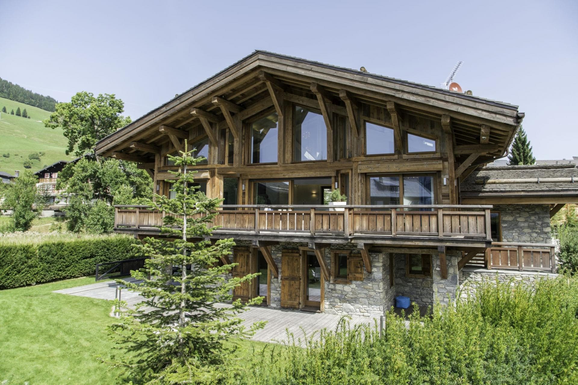 Chalet exterior with timber framing, stone ground level, and wrap-around balcony