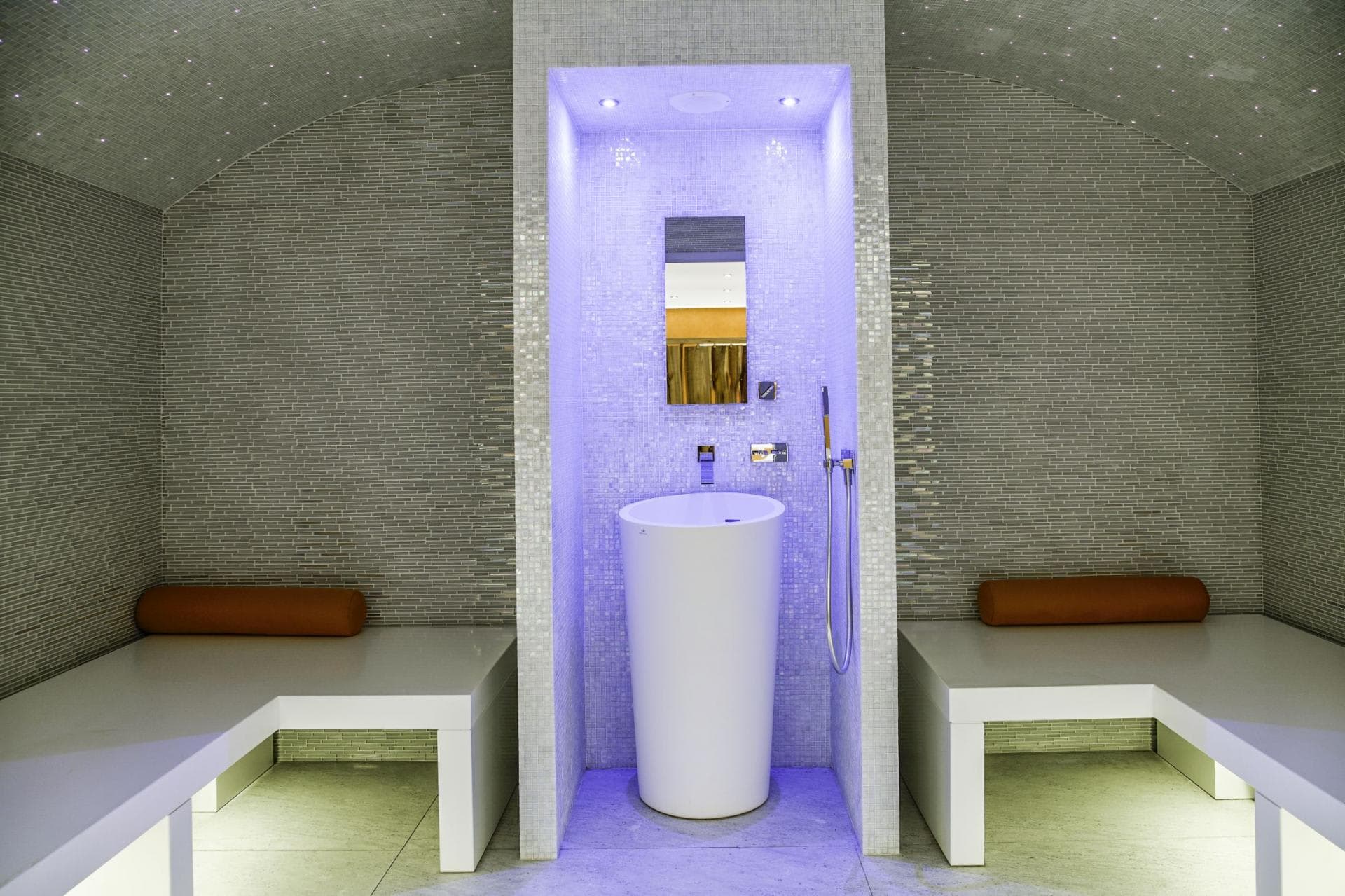 Private steam room with mosaic tile, pedestal sink, and fiber-optic ceiling