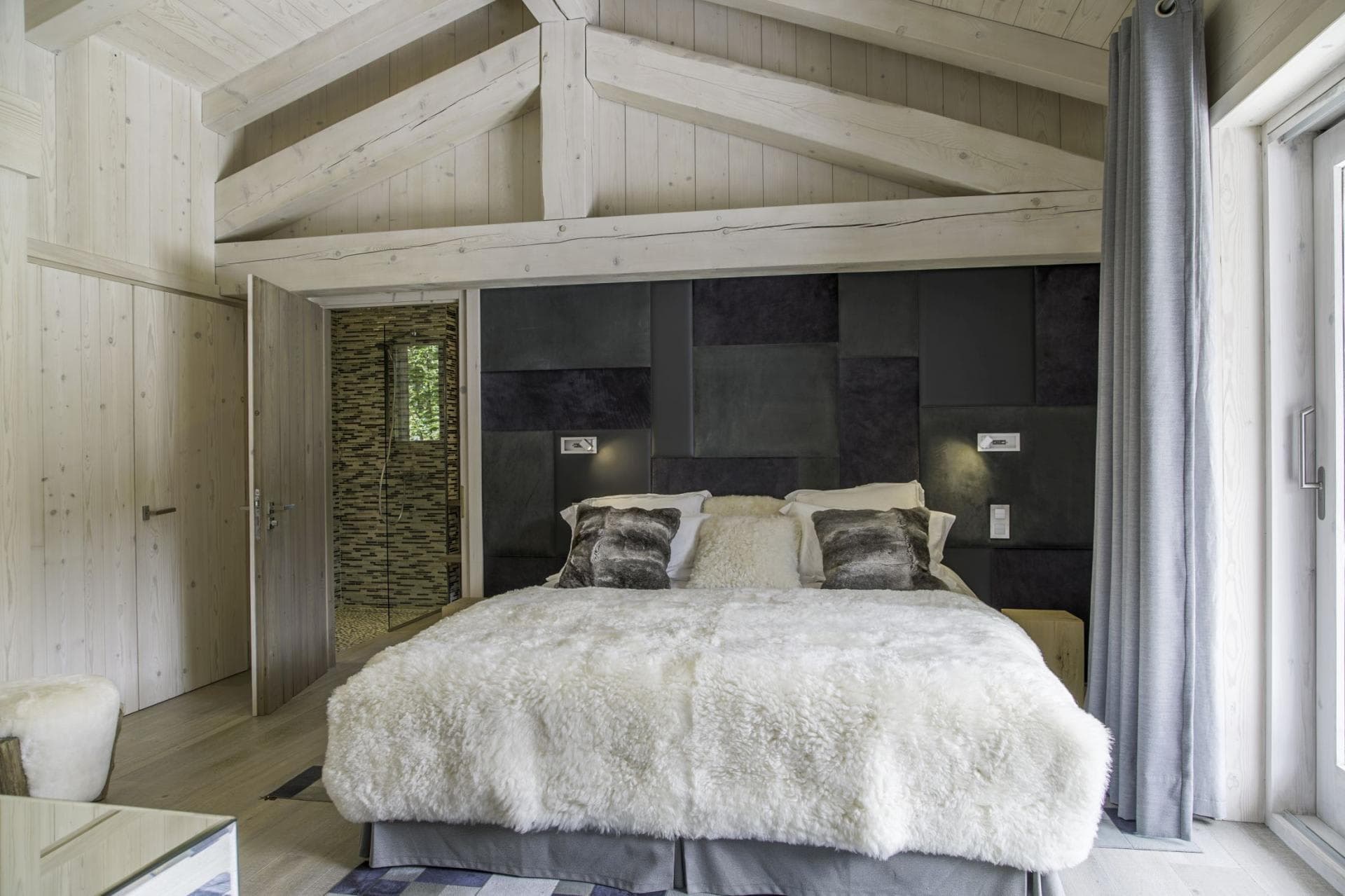 Primary bedroom with ensuite bathroom, vaulted ceilings, and balcony access