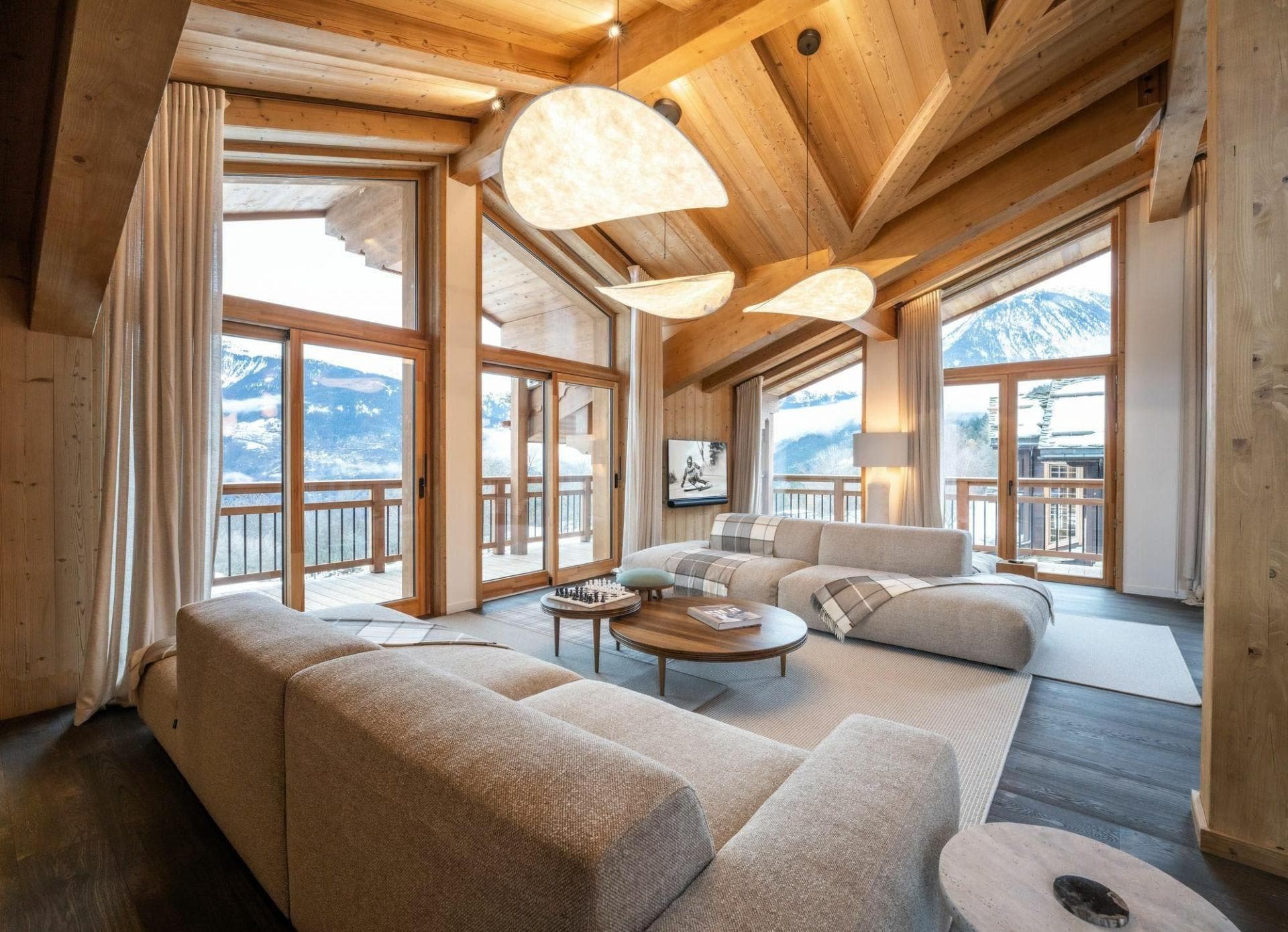 Living room with vaulted timber ceilings and floor-to-ceiling mountain views