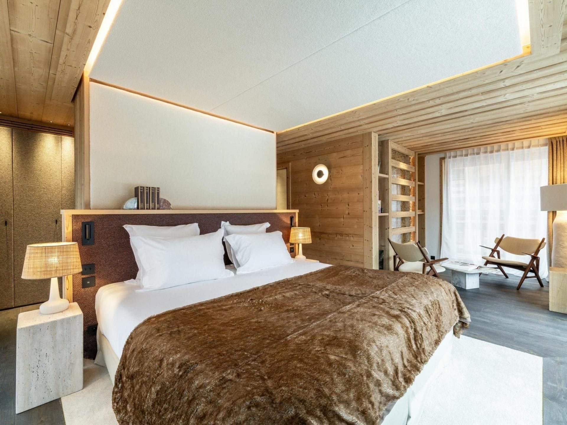 King bedroom with wood-paneled walls and separate seating area