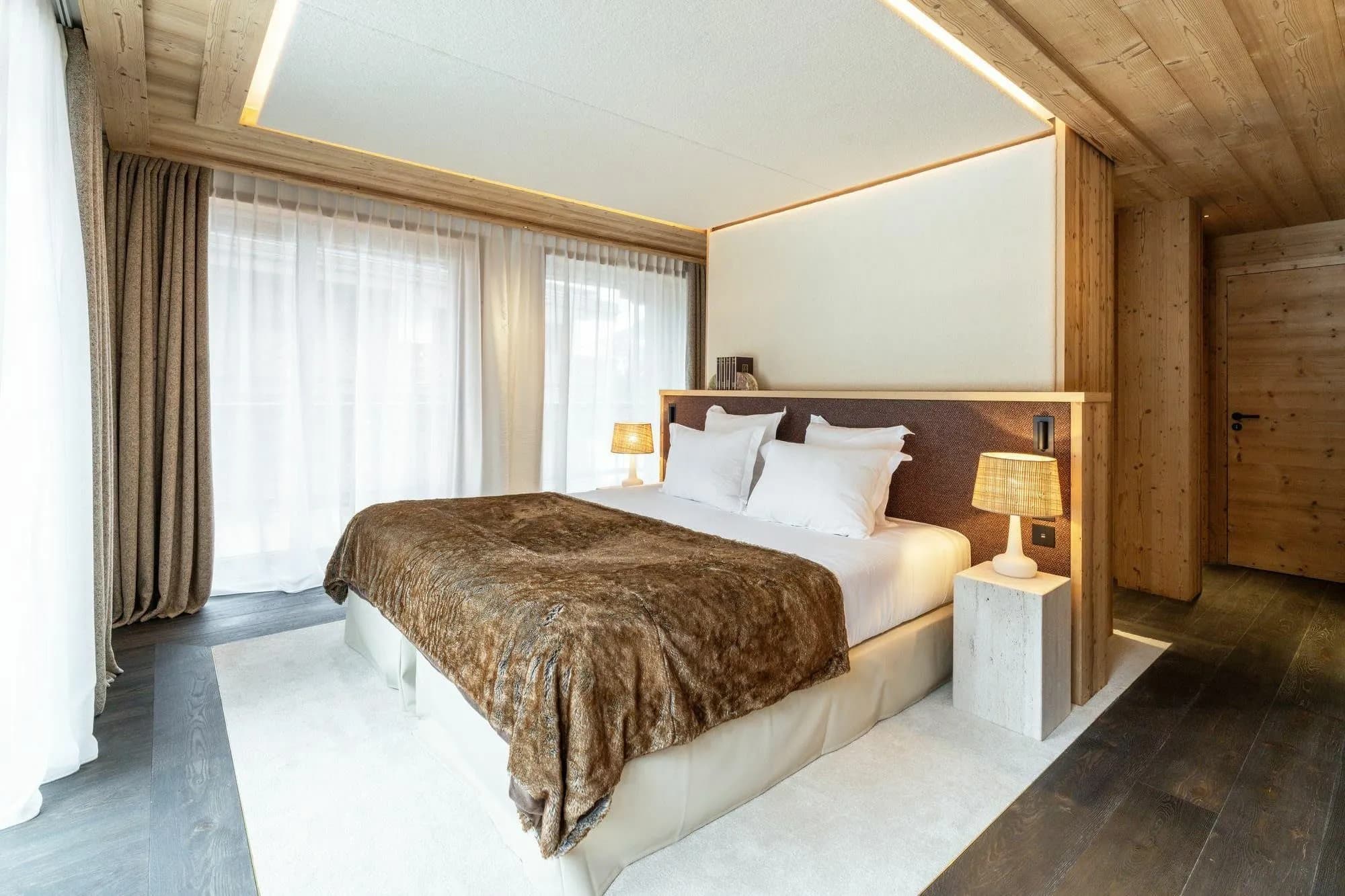 Master bedroom with a king-size bed and floor-to-ceiling curtains