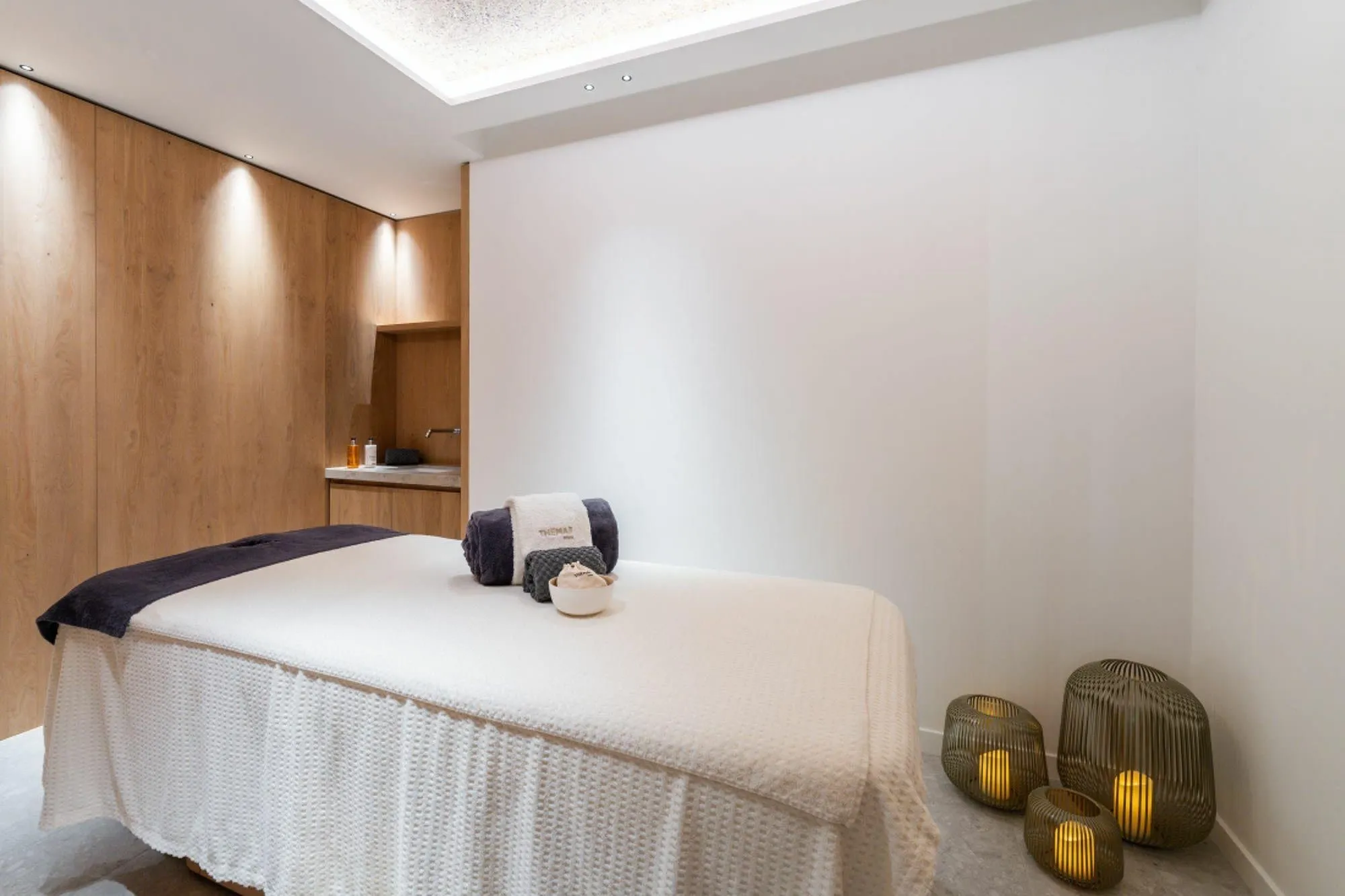 Private massage room with a treatment table and vanity sink