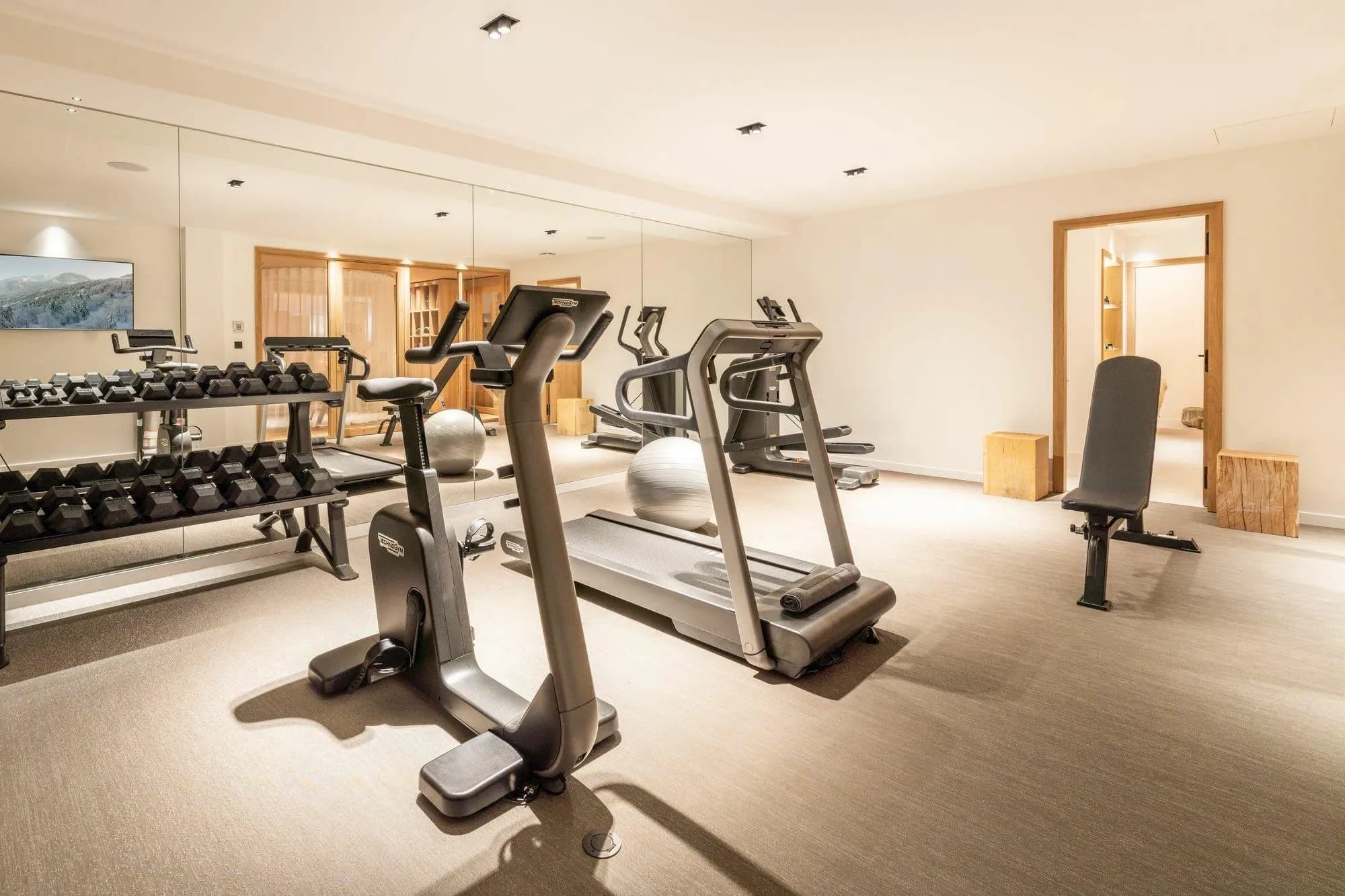Fitness room with exercise equipment and floor-to-ceiling mirrors