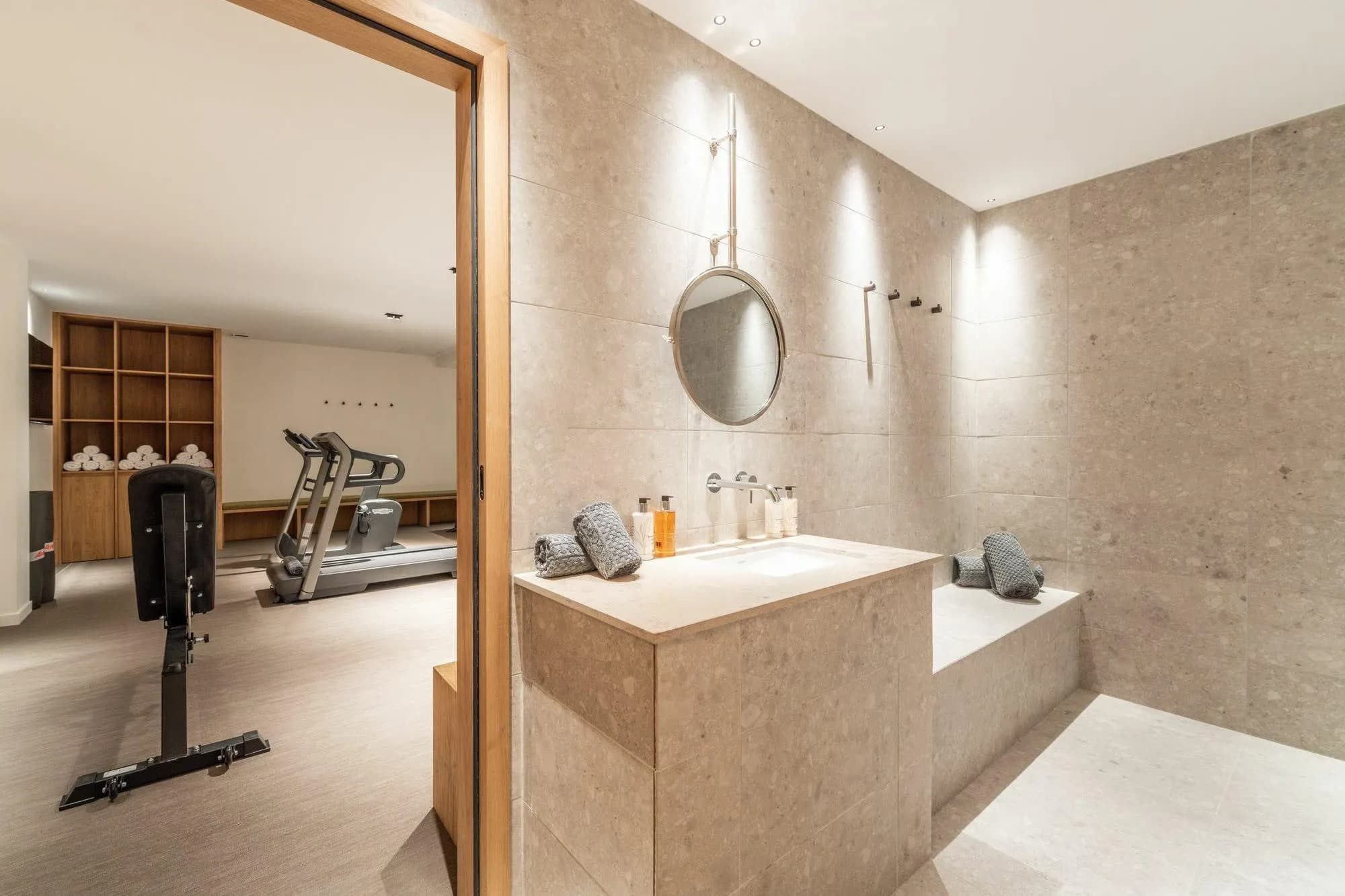 Stone vanity and shower area beside the fitness room