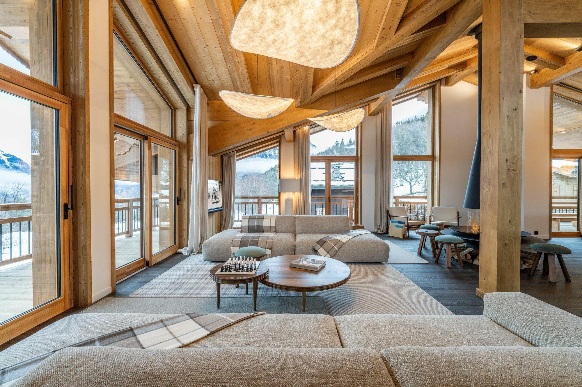 Living area with wood-burning fireplace and floor-to-ceiling mountain views