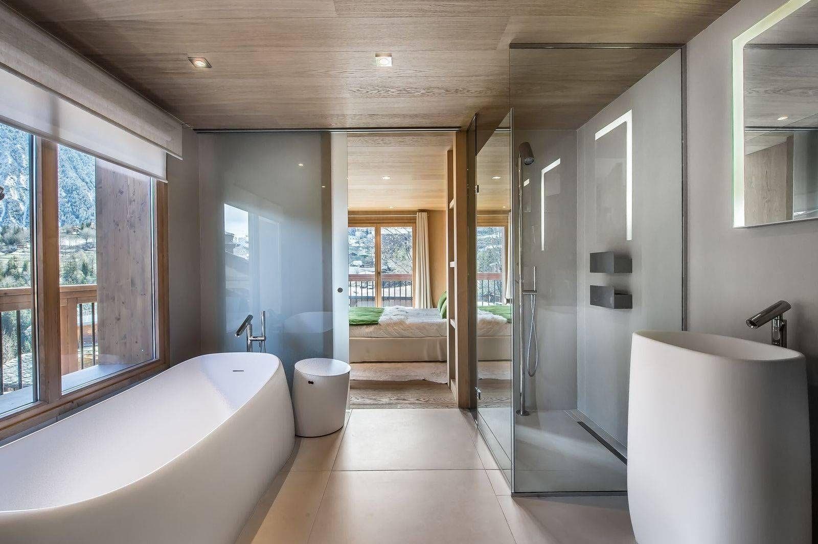En suite bathroom with soaking tub and glass-walled rainfall shower