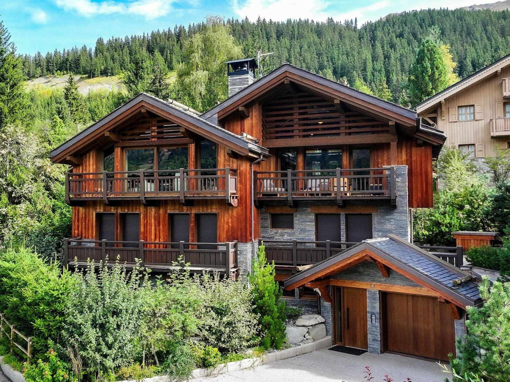 Chalet exterior with stone and wood facade; multi-level private balconies