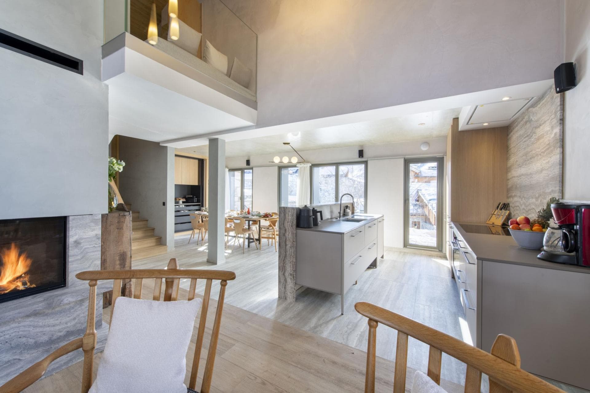 Open-plan kitchen and living area with wood-burning fireplace and mezzanine loft