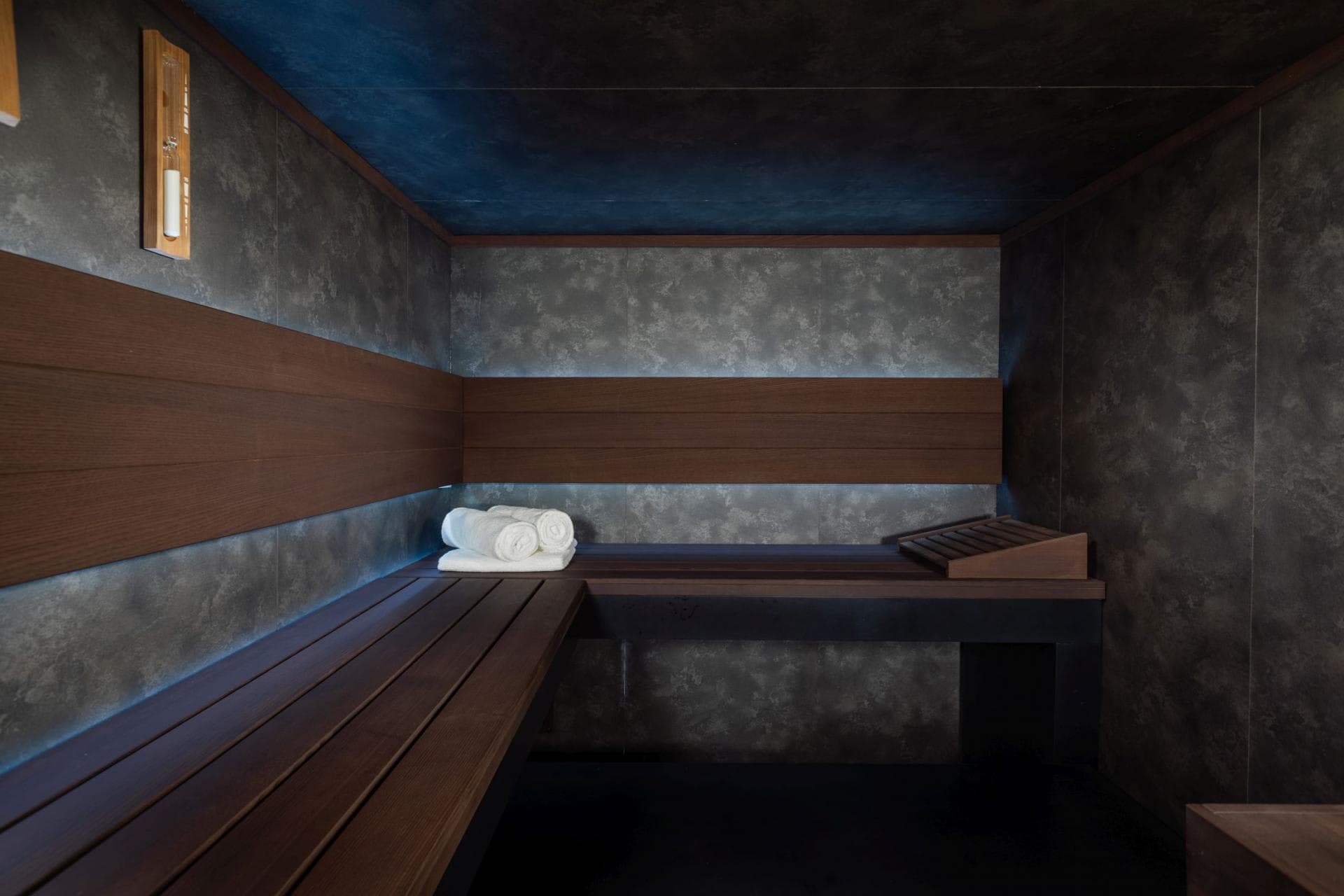 Private sauna with L-shaped cedar bench and integrated LED backlighting