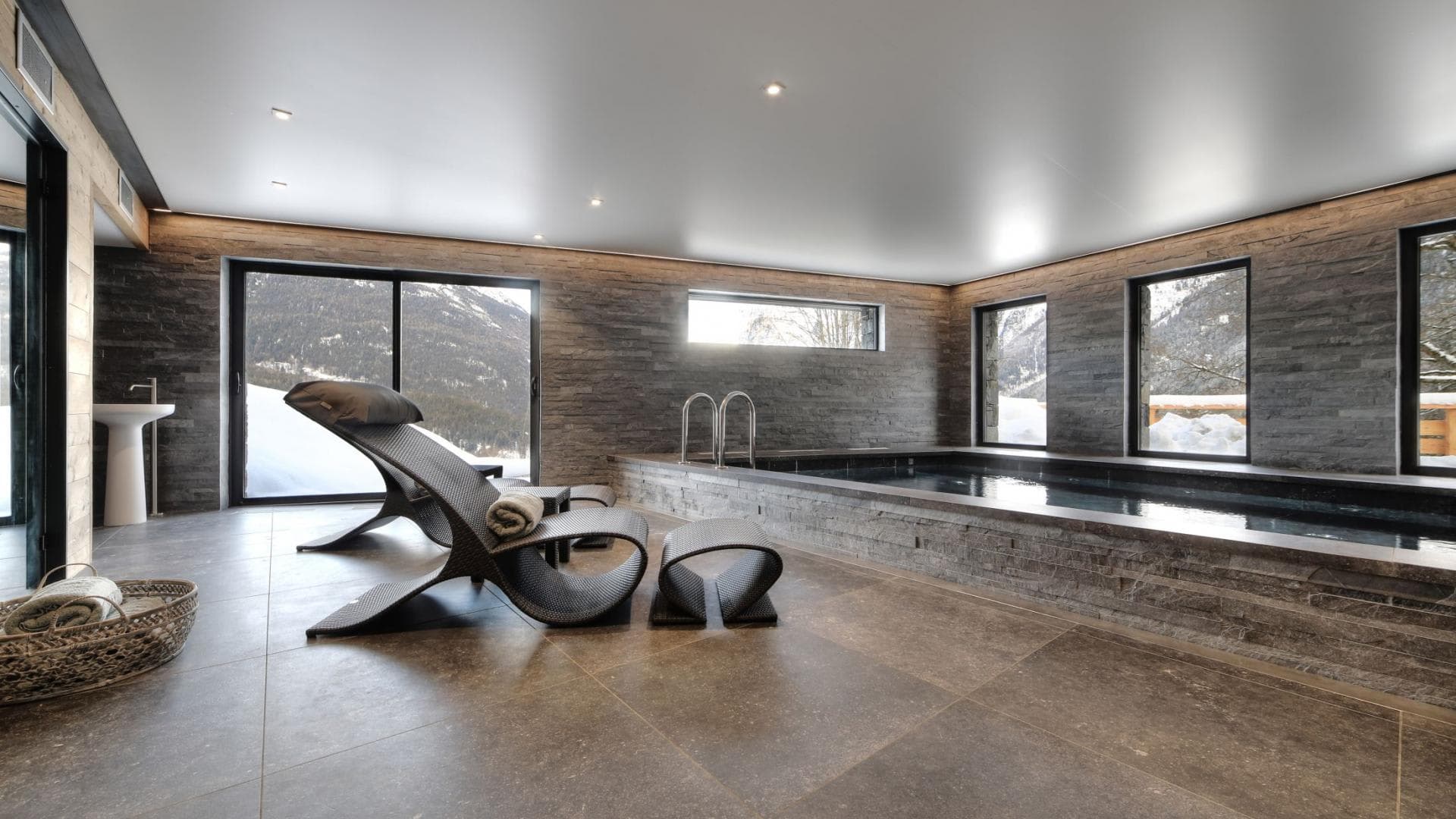 Indoor heated pool and lounge area with mountain views