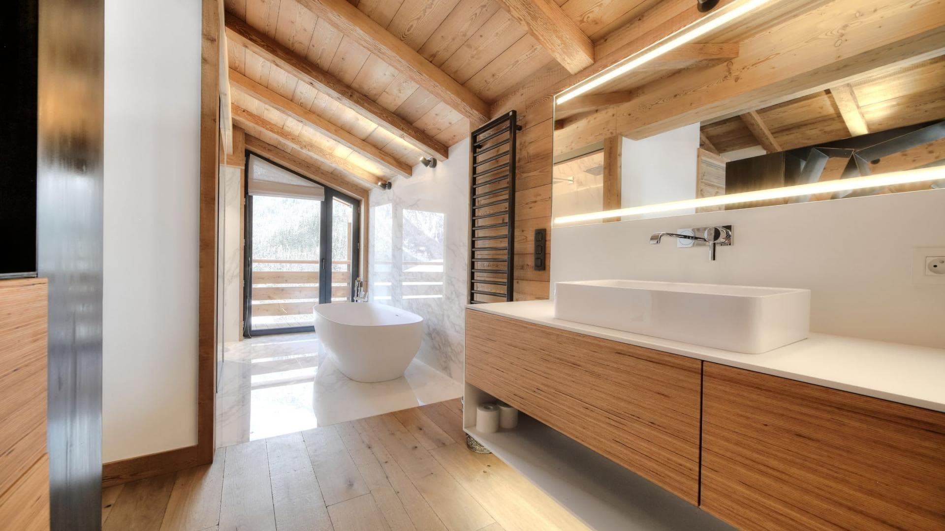 Bathroom with freestanding soaking tub and heated towel rack