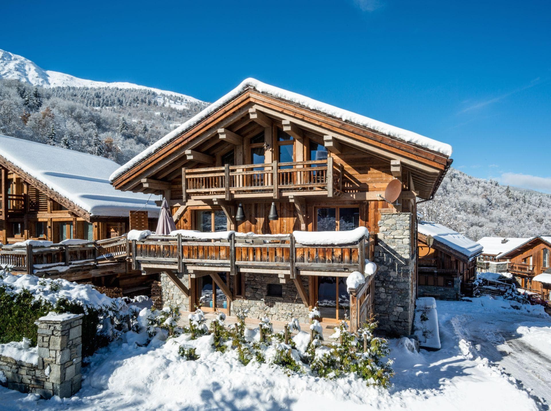 Ski-in chalet exterior with multi-level timber balconies and mountain views