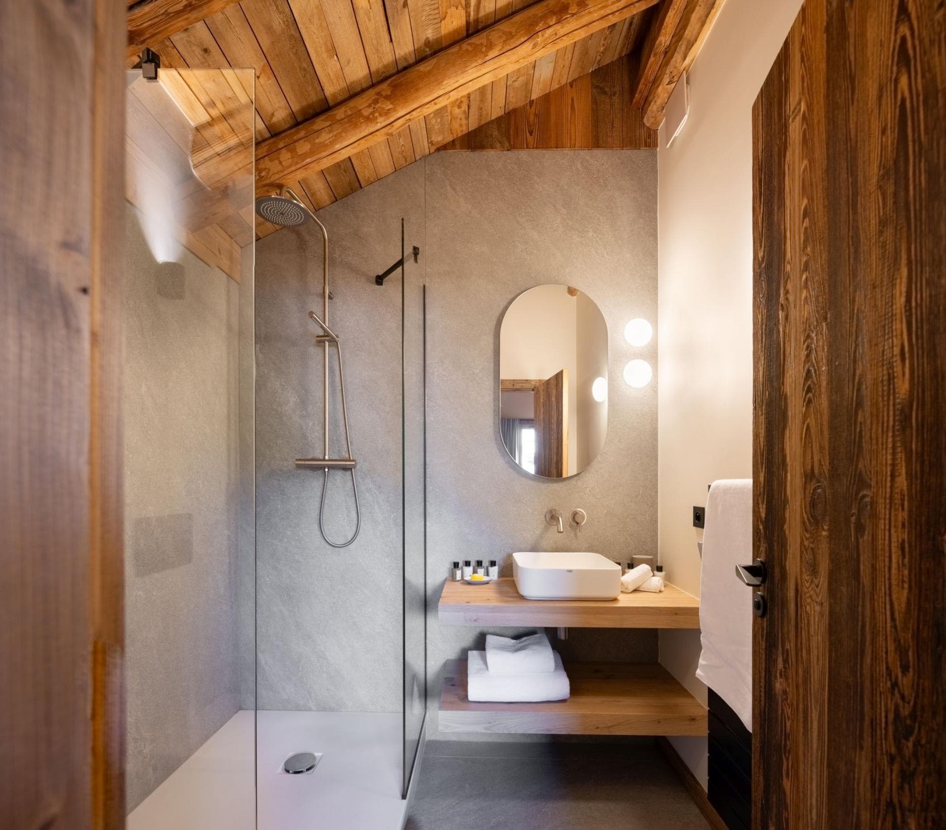 Bathroom with walk-in rainfall shower and sloped wooden ceiling