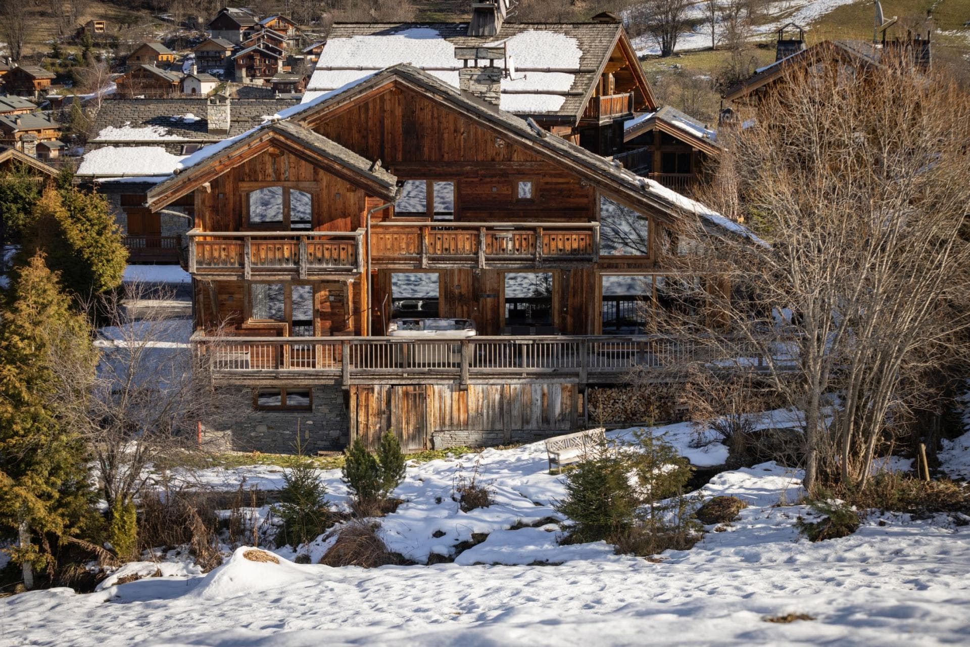 Chalet exterior with multi-level balconies and private hot tub on deck