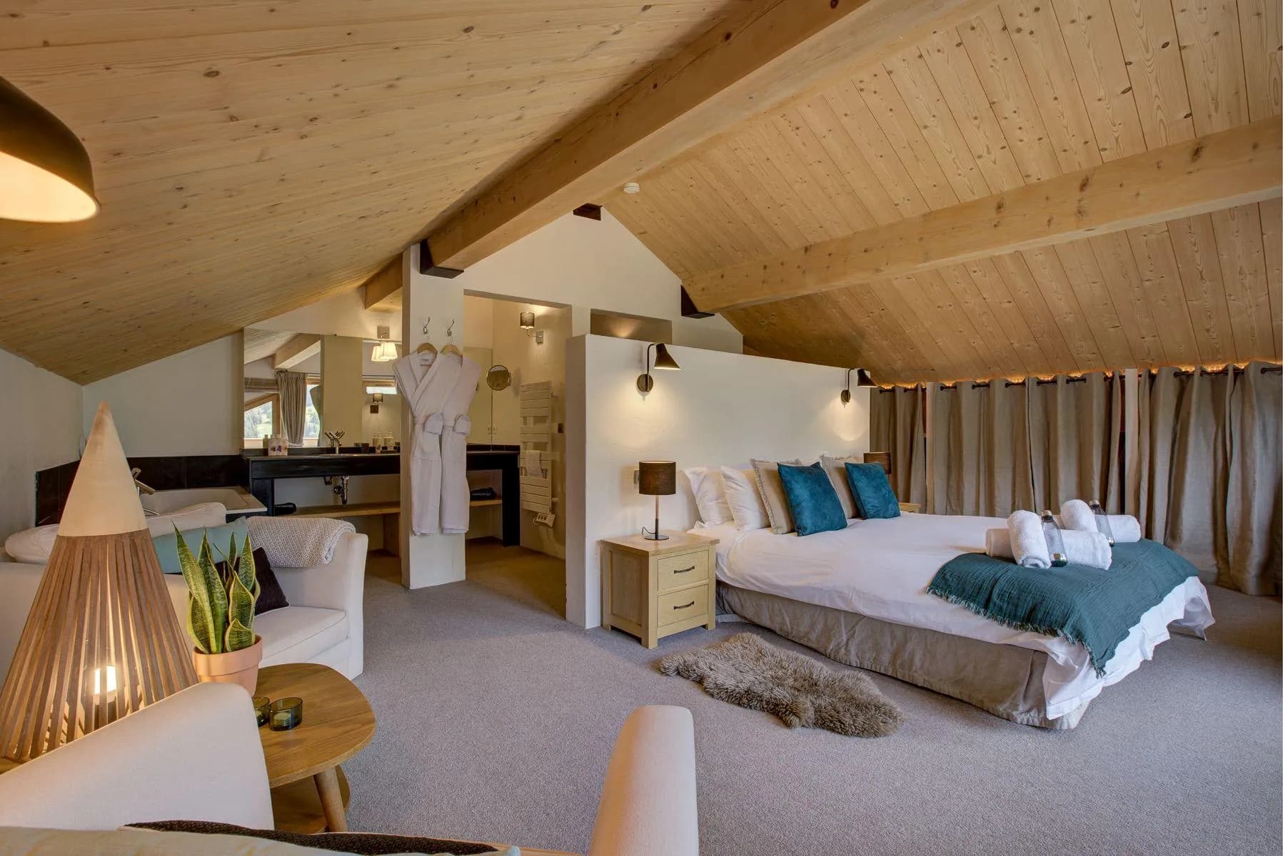 Master suite with a double bed, vaulted timber ceiling and open bathroom