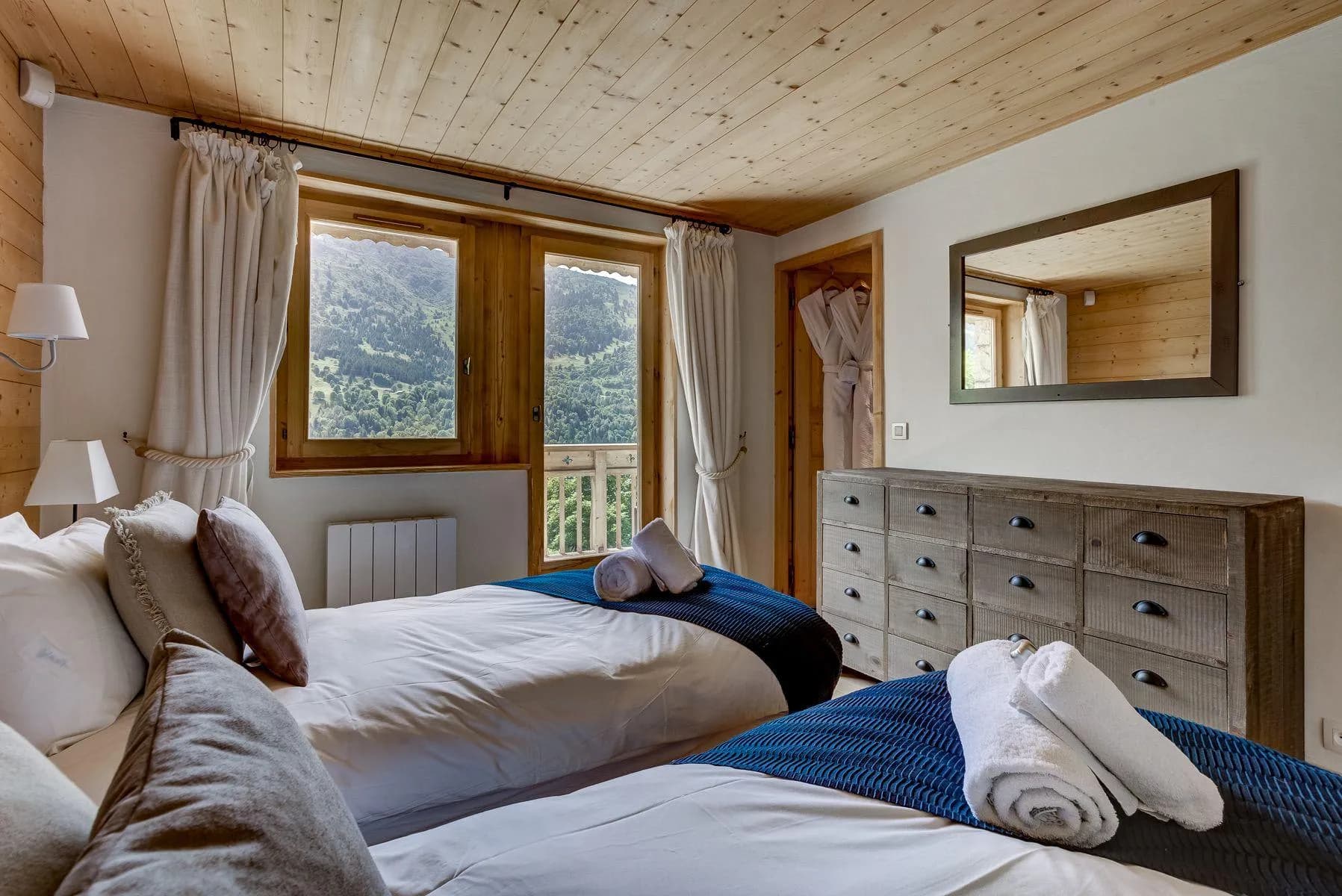 Twin bedroom with timber walls and mountain views