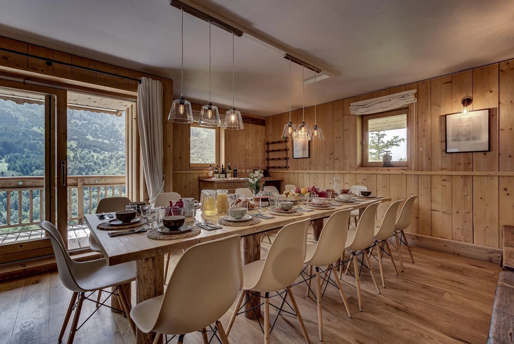 Dining room set for breakfast beside windows and balcony doors