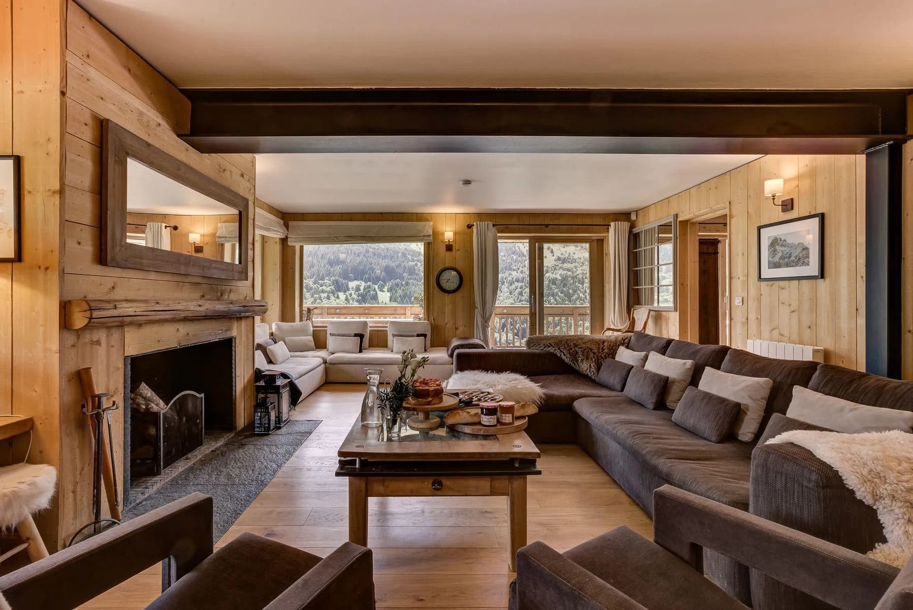 Living room with two seating areas, an open fireplace and valley views