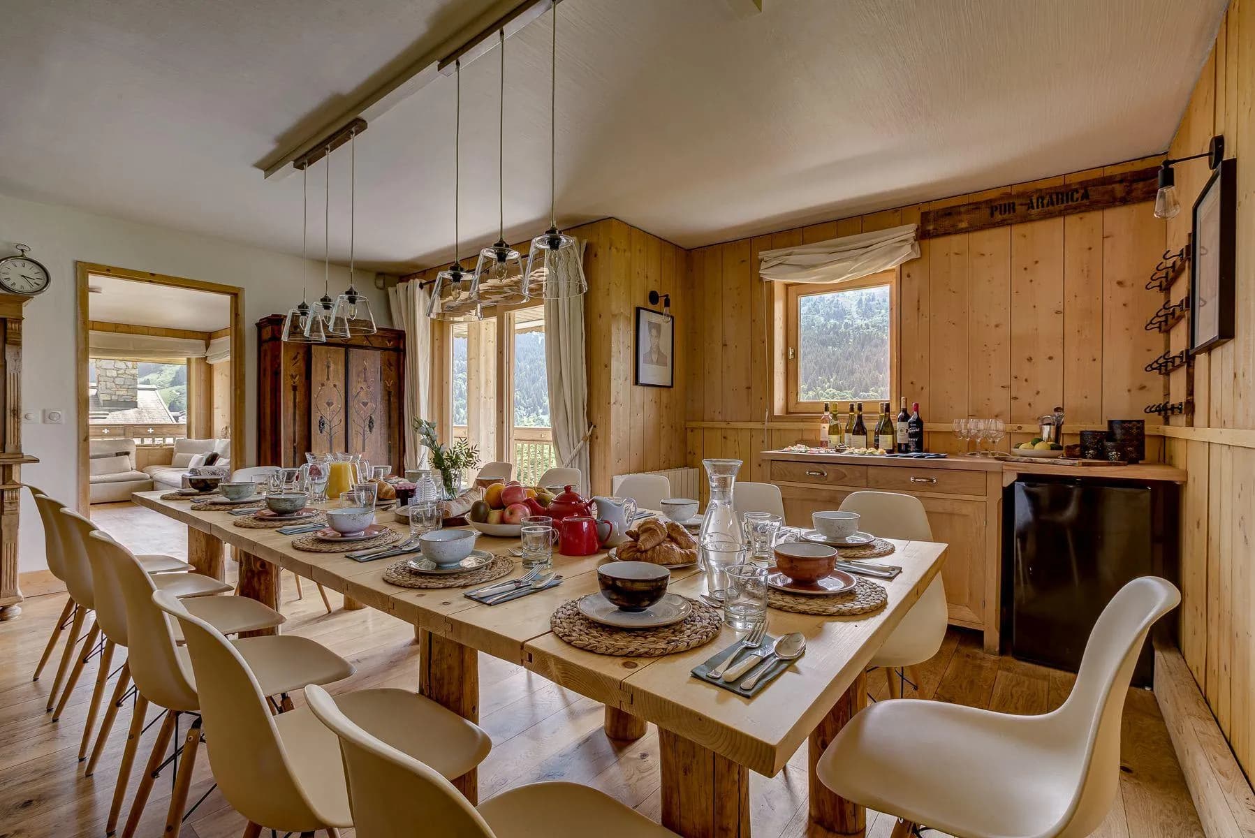 Timber dining room with a long table and mountain views