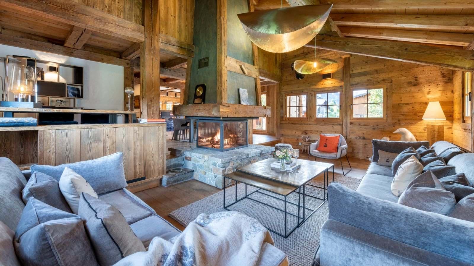 Living area with 360-degree glass fireplace and reclaimed timber beams
