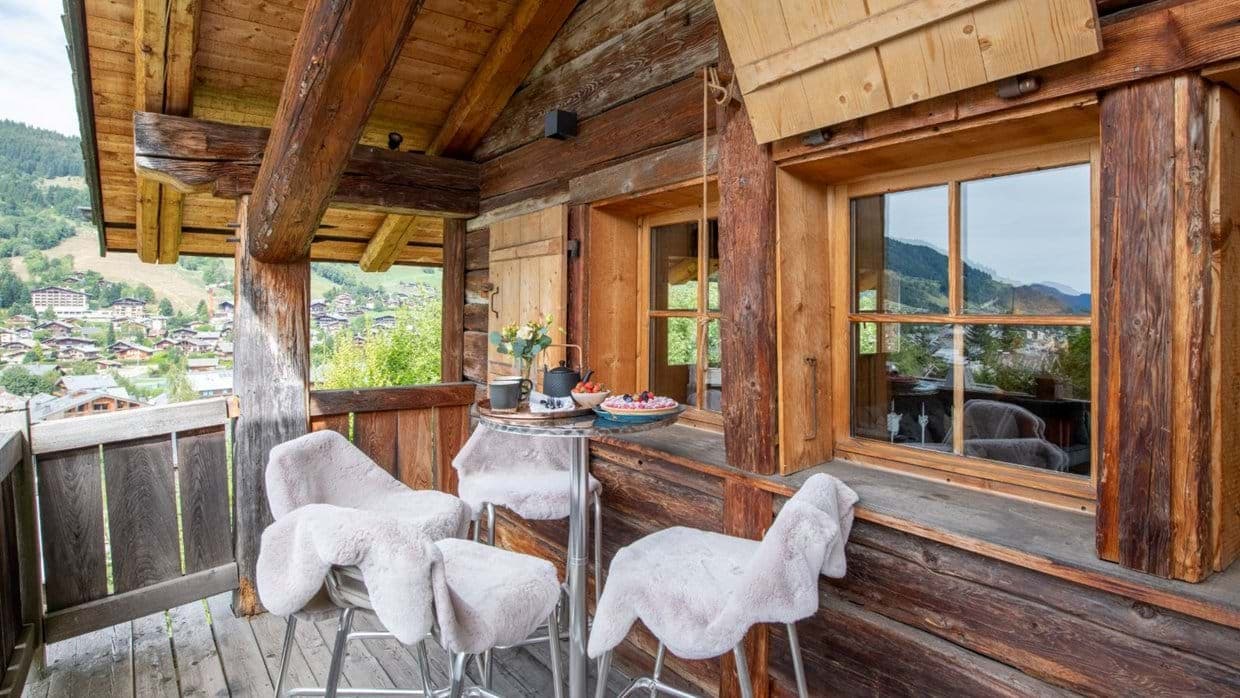 Covered timber balcony with bistro seating and valley views