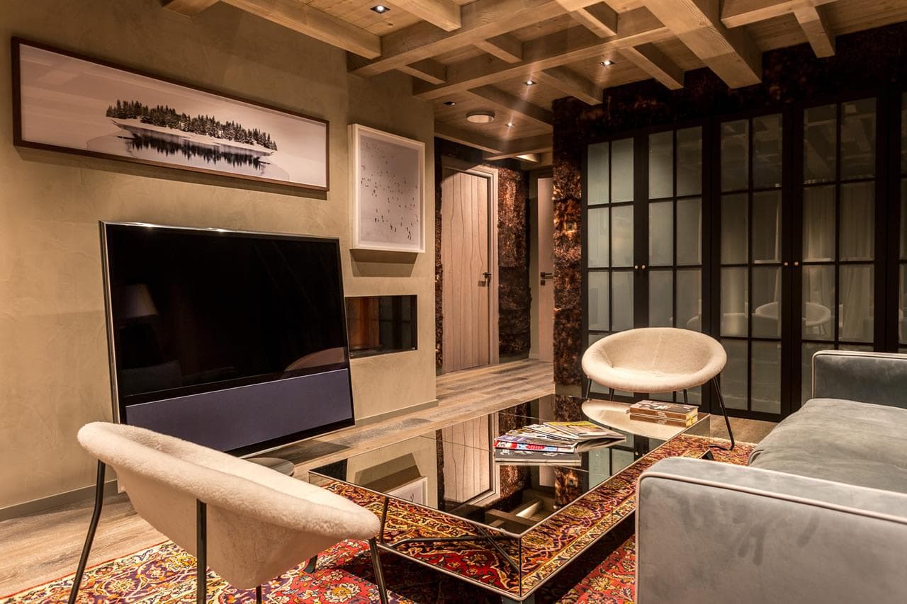 Media room with Bang & Olufsen TV and wood-beamed ceiling