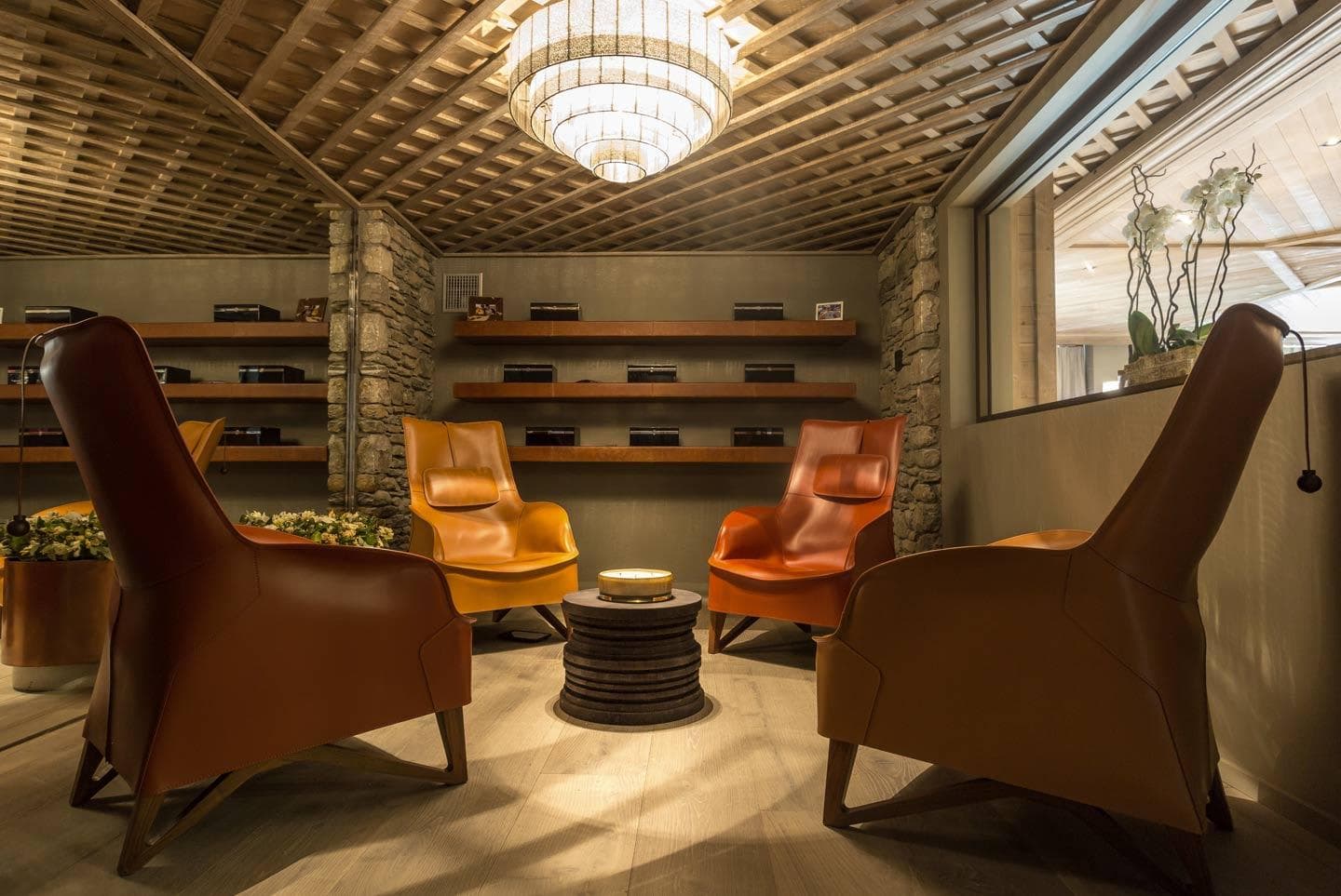 Cigar lounge with leather armchairs and humidors; stone wall accents
