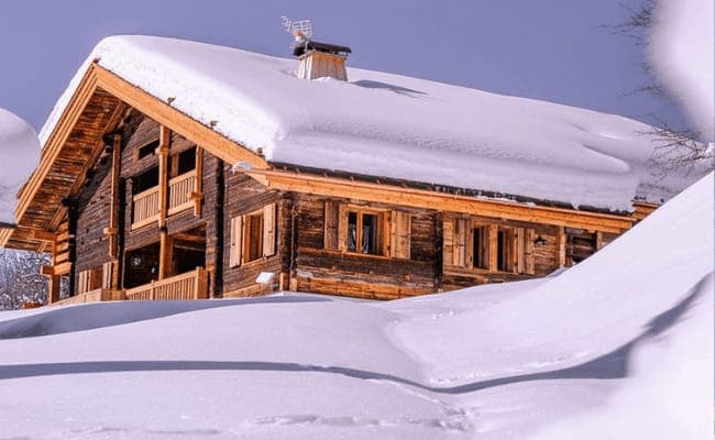 Timber chalet exterior with multi-level balconies and traditional shutters