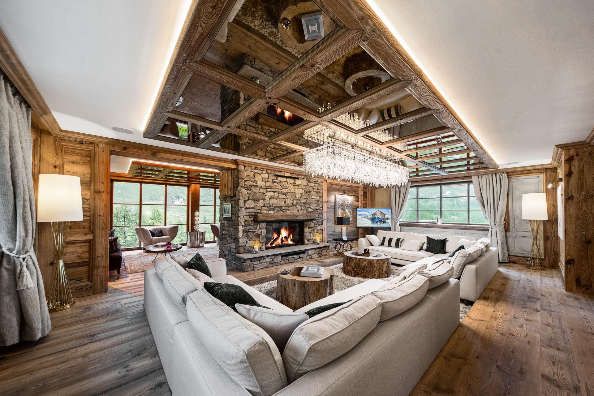Living area with wood-burning stone fireplace and mirrored coffered ceiling
