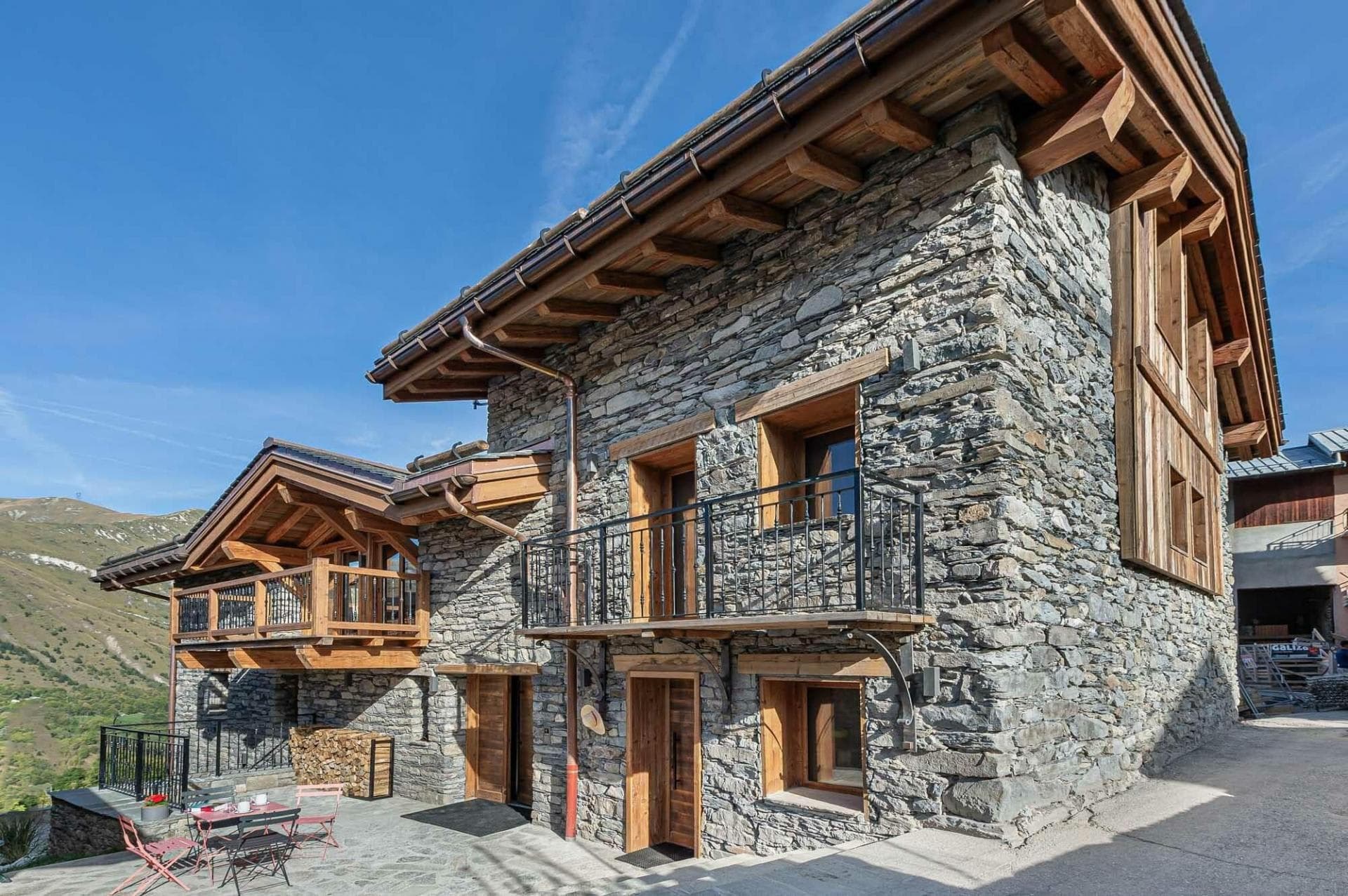 Chalet exterior with stone masonry, private balconies, and flagstone terrace