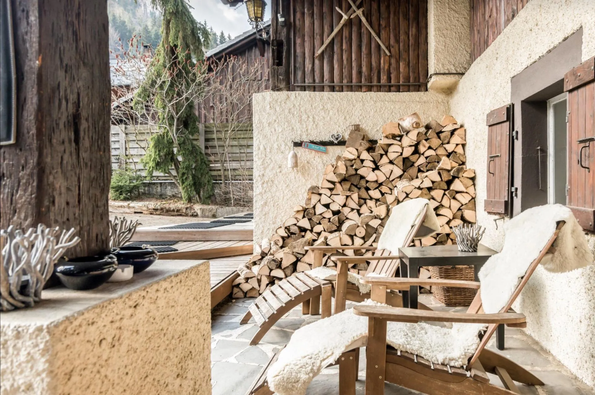 Stone patio with lounge chairs and firewood storage