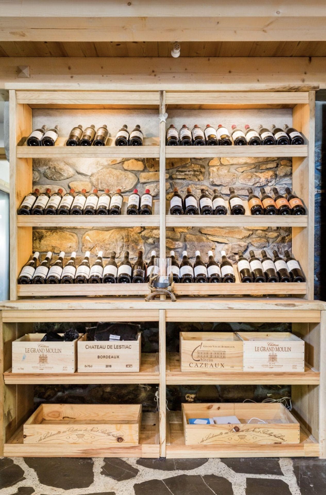 Wine cellar with built-in timber shelving and original stone walls