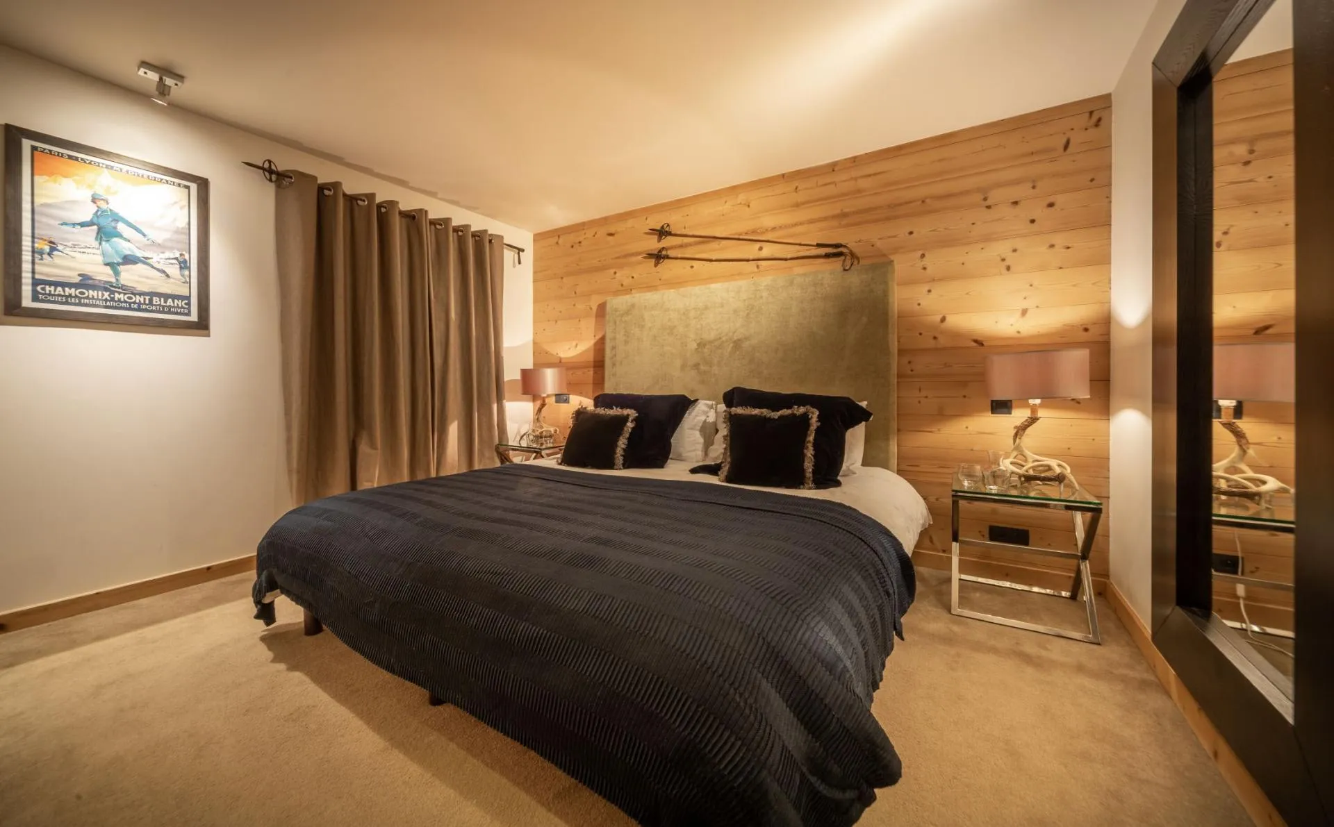 Bedroom with king bed, timber walls and antler-base lamps