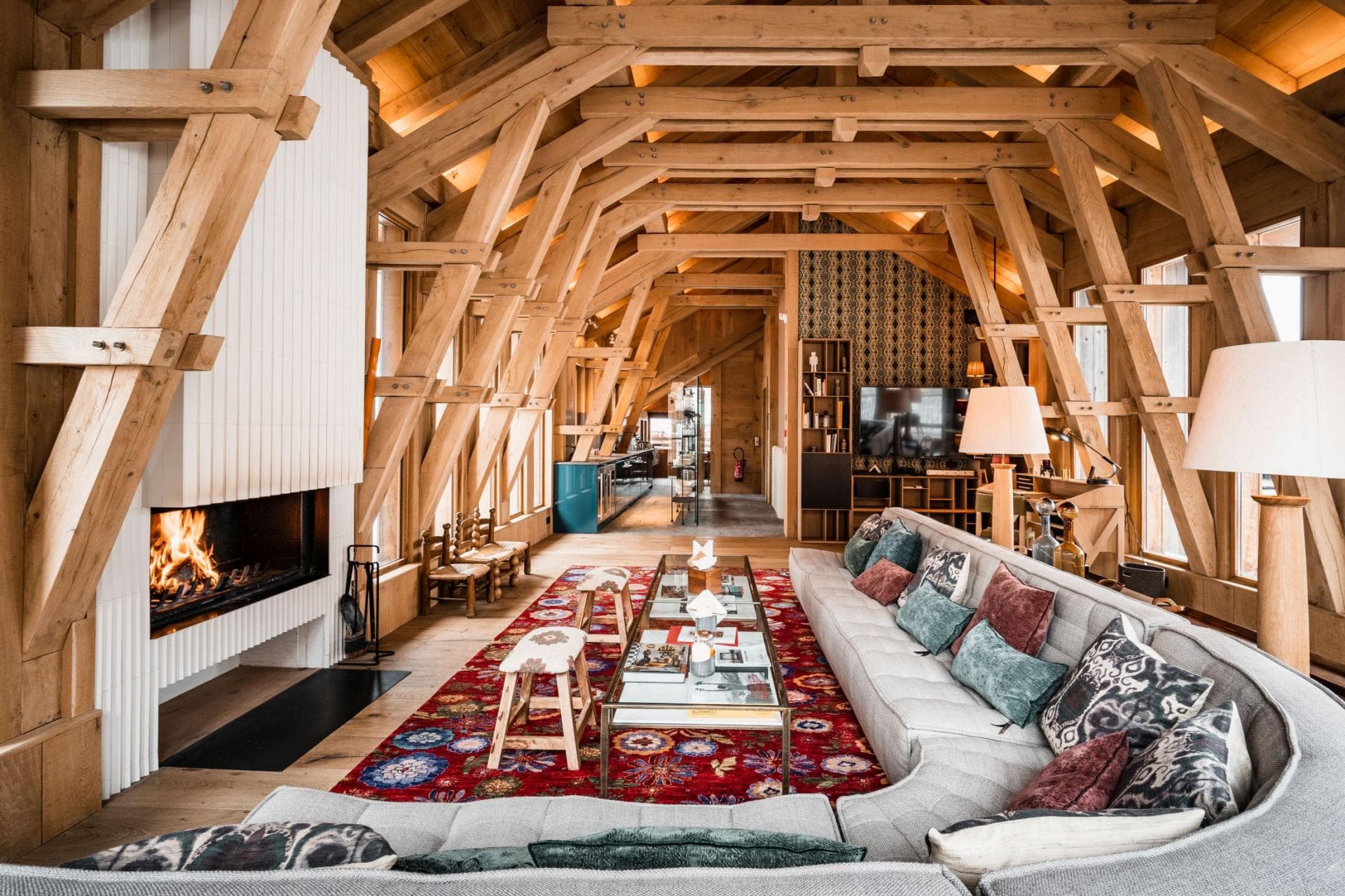 Living area with wood-burning fireplace and exposed timber trusses