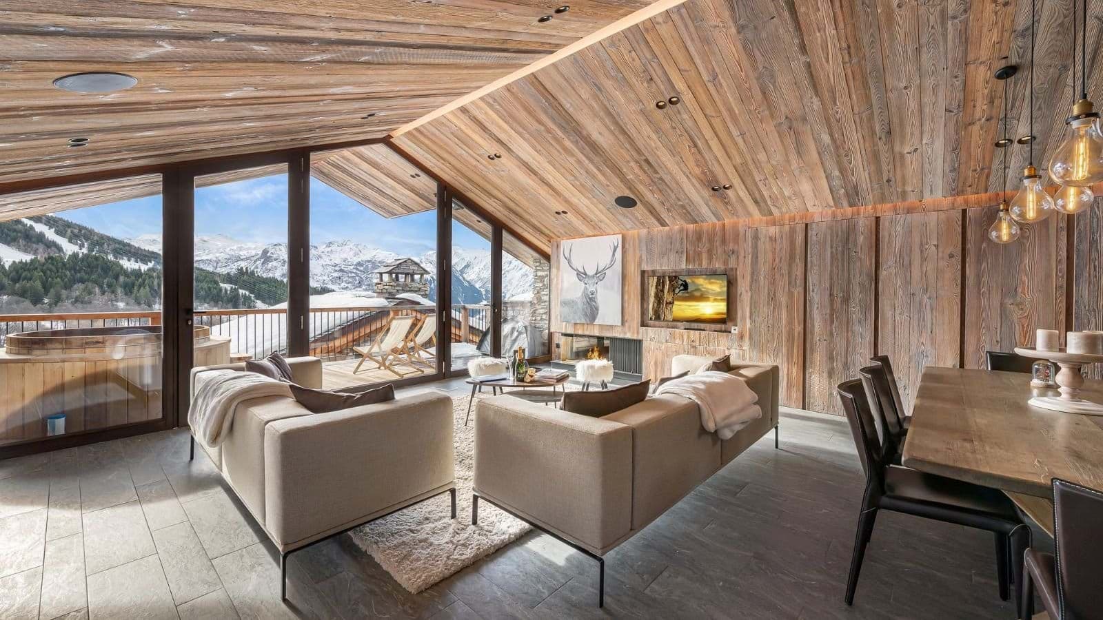 Open-plan living area with fireplace and balcony access to outdoor hot tub